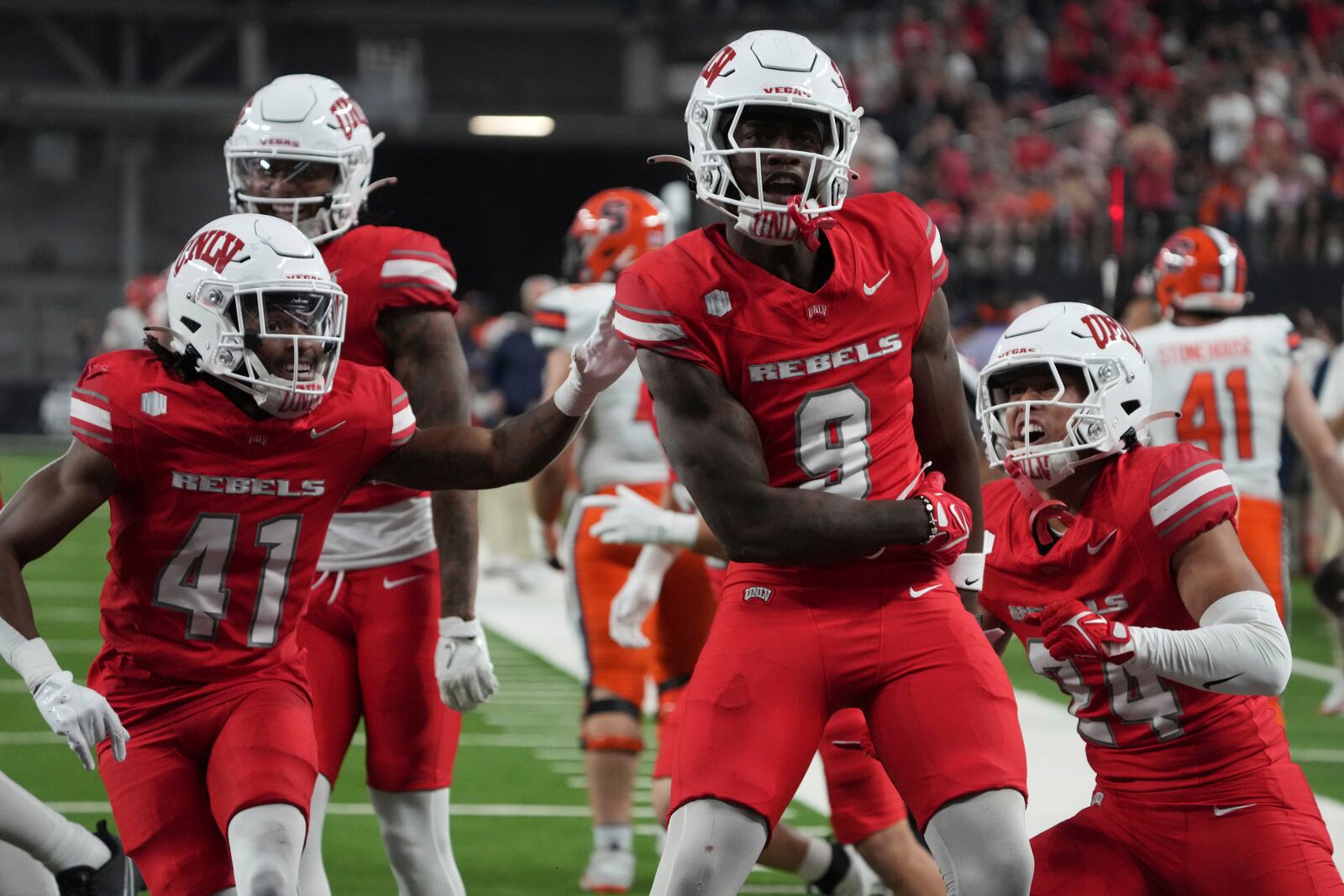 UNLV defensive back Jett Elad (9) celebrates with teammates after stopping the Syracuse offensive on fourth down in the first half during an NCAA college football game, Friday, Oct. 4, 2024, in Las Vegas. (AP Photo/Rick Scuteri)