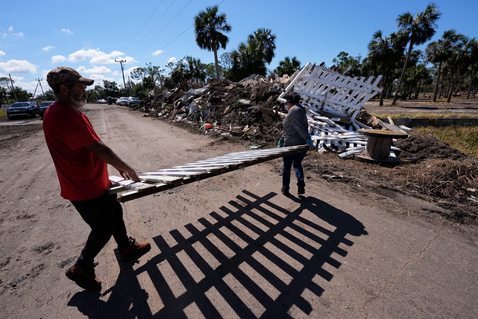 Workers pile debris in the aftermath of Hurricane Helene, in Jena, Fla., Sunday, Sept. 29, 2024. (AP Photo/Gerald Herbert)