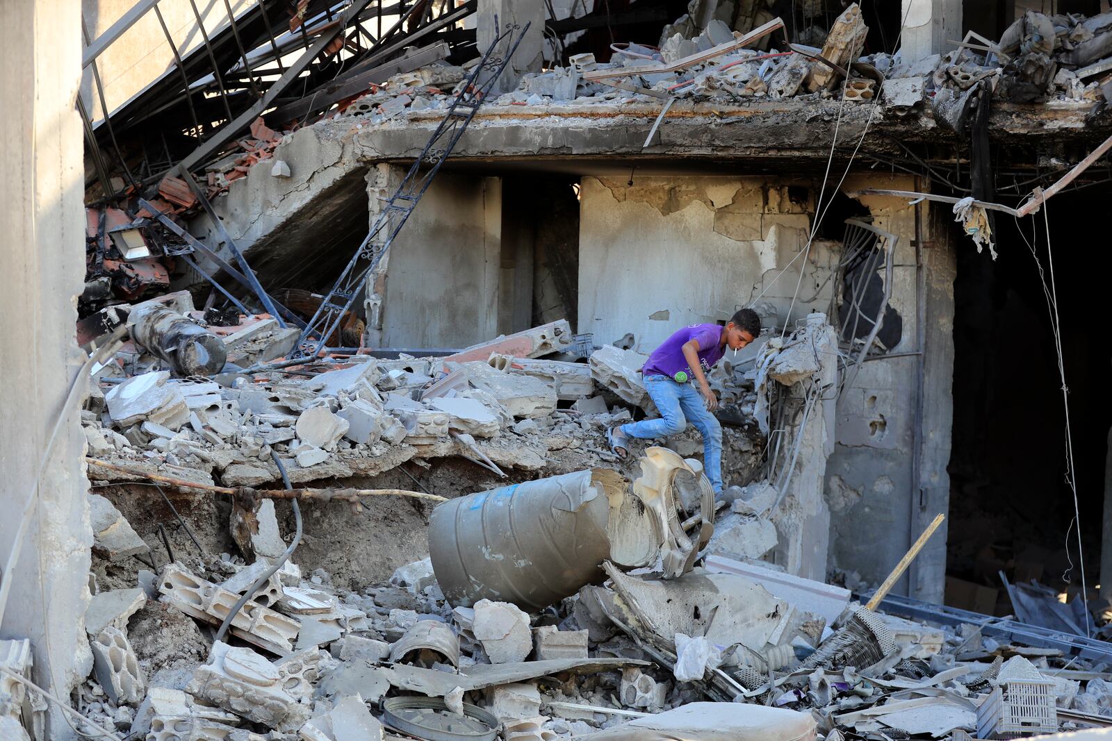 A boy checks the damage to a building hit in an Israeli airstrike in the southern village of Akbieh, Lebanon, Tuesday, Sept. 24, 2024. (AP Photo/Mohammed Zaatari)