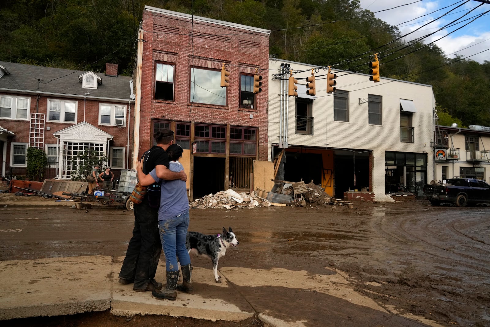 FILE - Resident Anne Schneider, right, hugs her friend Eddy Sampson as they survey damage left in the wake of Hurricane Helene, Oct. 1, 2024, in Marshall, N.C. (AP Photo/Jeff Roberson, File)