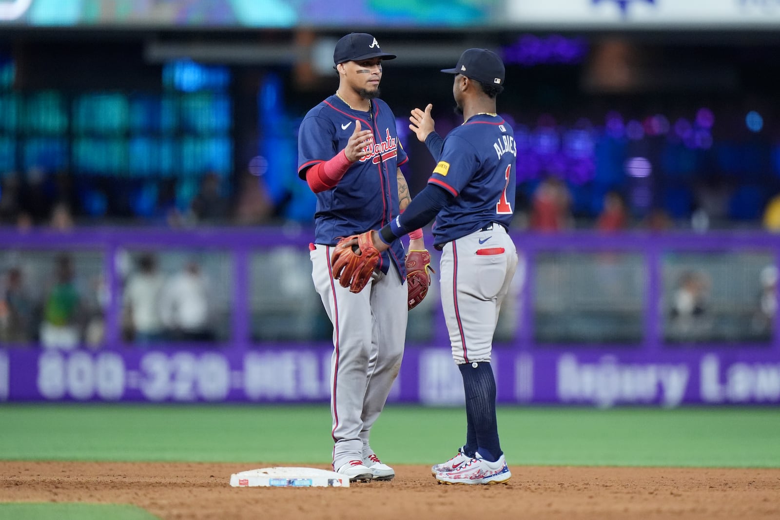 Atlanta Braves shortstop Orlando Arcia, left, and second baseman Ozzi Albies (1) congratulate each other after the Braves beat the Miami Marlins 5-4, during a baseball game, Sunday, Sept. 22, 2024, in Miami. (AP Photo/Wilfredo Lee)