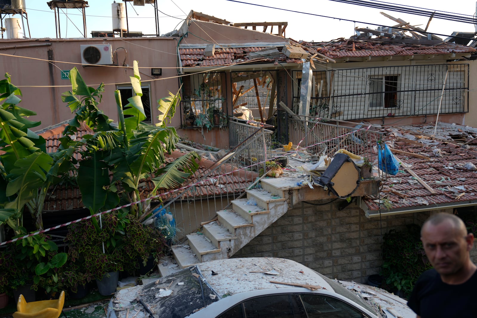 A member of Israeli security forces surveys damage to a home struck by a rocket fired from Lebanon in the town of Majd al-Krum, northern Israel, Wednesday, Oct. 16, 2024. (AP Photo/Ariel Schalit)