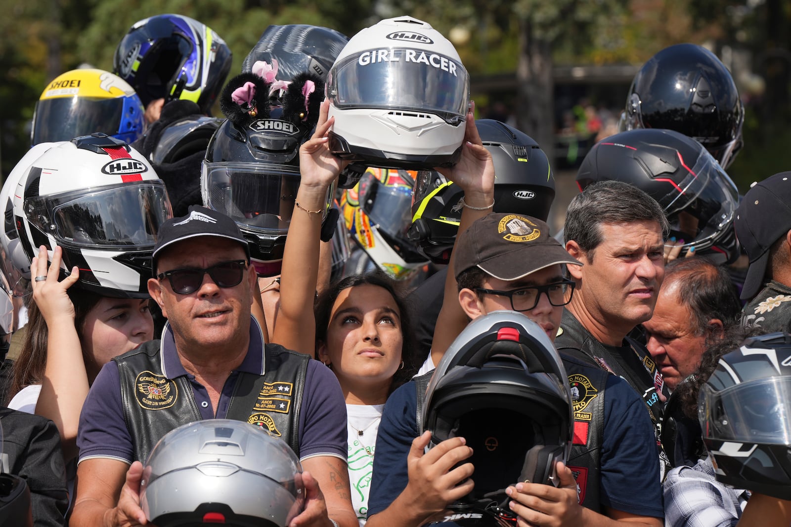 Faithful hold up their helmets to be blessed during the IX Pilgrimage of the Blessing of Helmets that draws tens of thousands at the Roman Catholic holy shrine of Fatima, in Fatima, Portugal, Sunday, Sept. 22, 2024. (AP Photo/Ana Brigida)