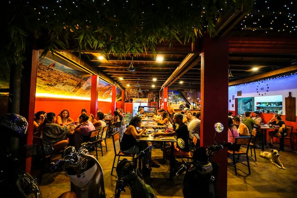 Foreign tourists have a drink at a night club at Nana Backpack hostel in Vang Vieng, Laos, Tuesday, Nov. 19, 2024. (AP Photo/Anupam Nath)