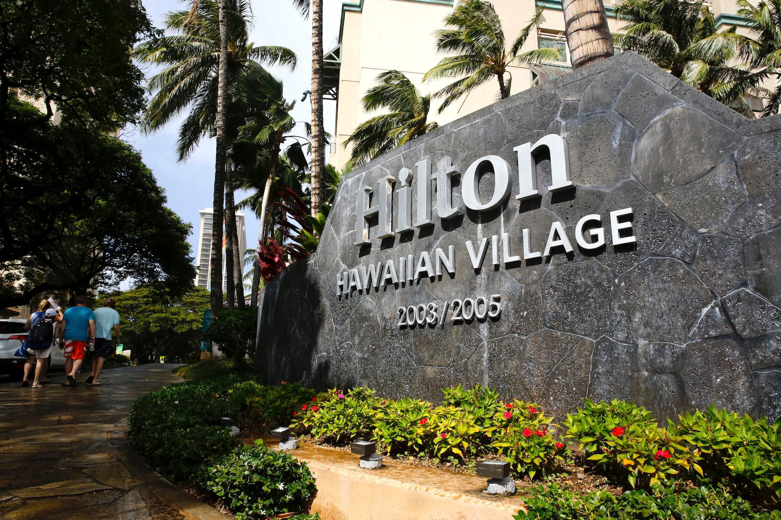 FILE - People walk into the Hilton Hawaiian Village resort in Honolulu, on Saturday, Sept. 4, 2021. (AP Photo/Caleb Jones, File)