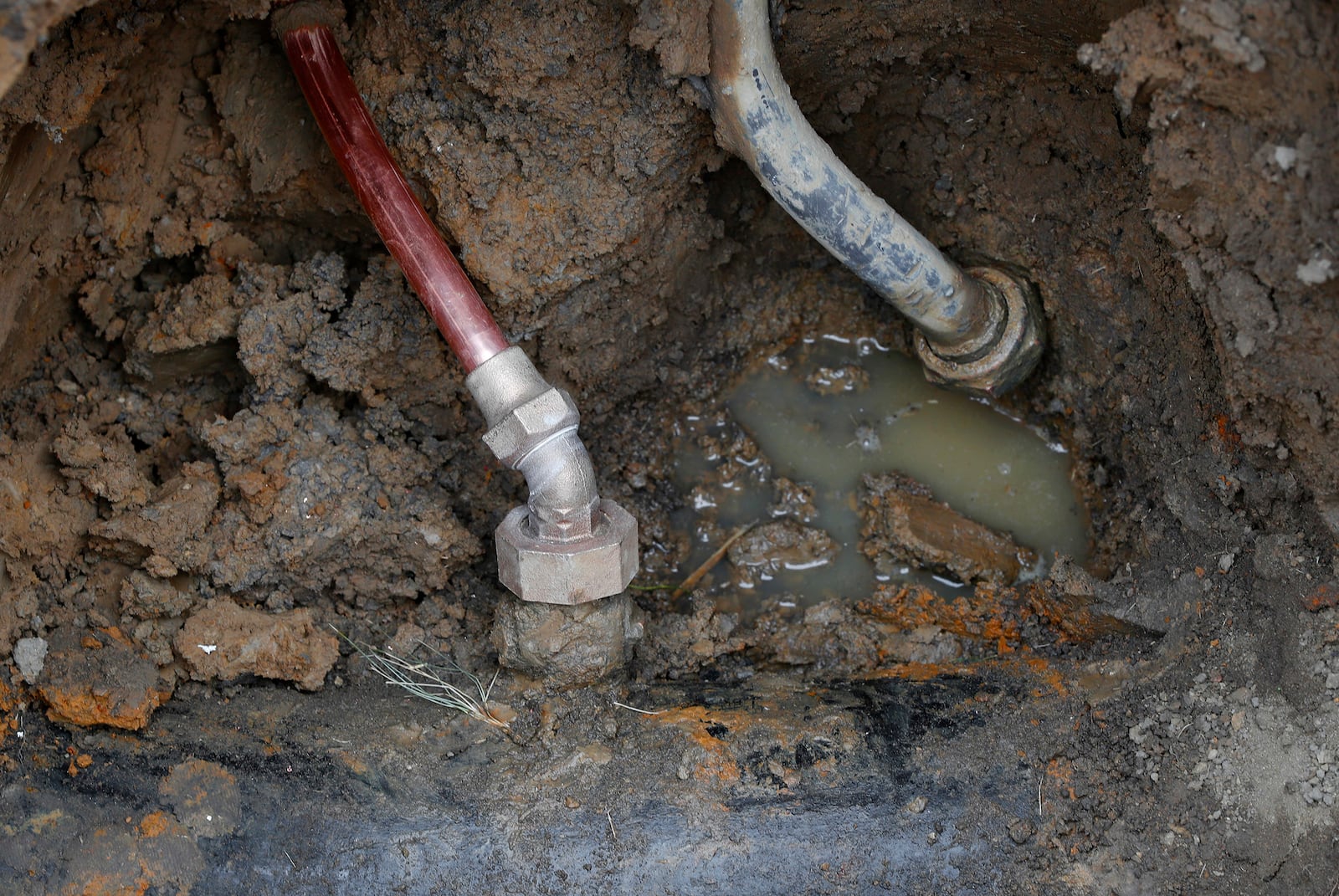 FILE - A copper water supply line, left, is shown connected to a water main after being installed for lead pipe, right, July 20, 2018, in Flint, Mich. (AP Photo/Paul Sancya, File)