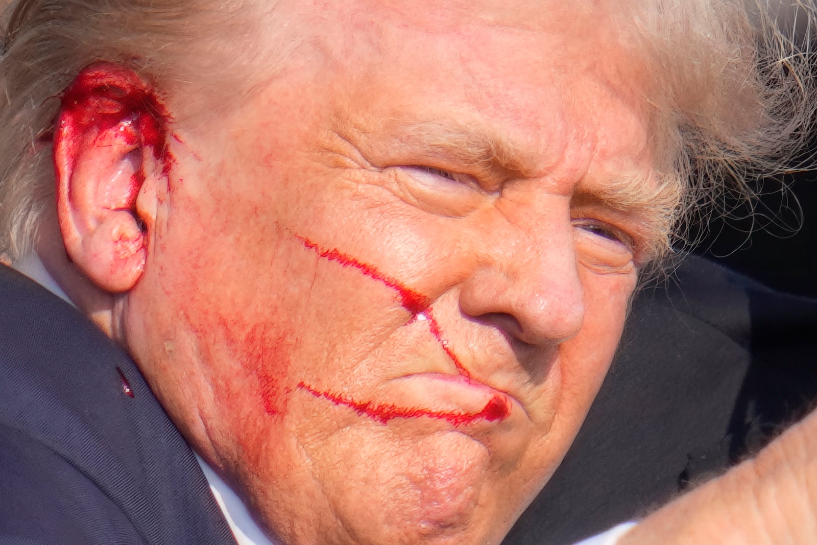 FILE -Republican presidential candidate former President Donald Trump gestures as he is surrounded by U.S. Secret Service agents as he is helped off the stage at a campaign rally in Butler, Pa., July 13, 2024. (AP Photo/Gene J. Puskar, File)