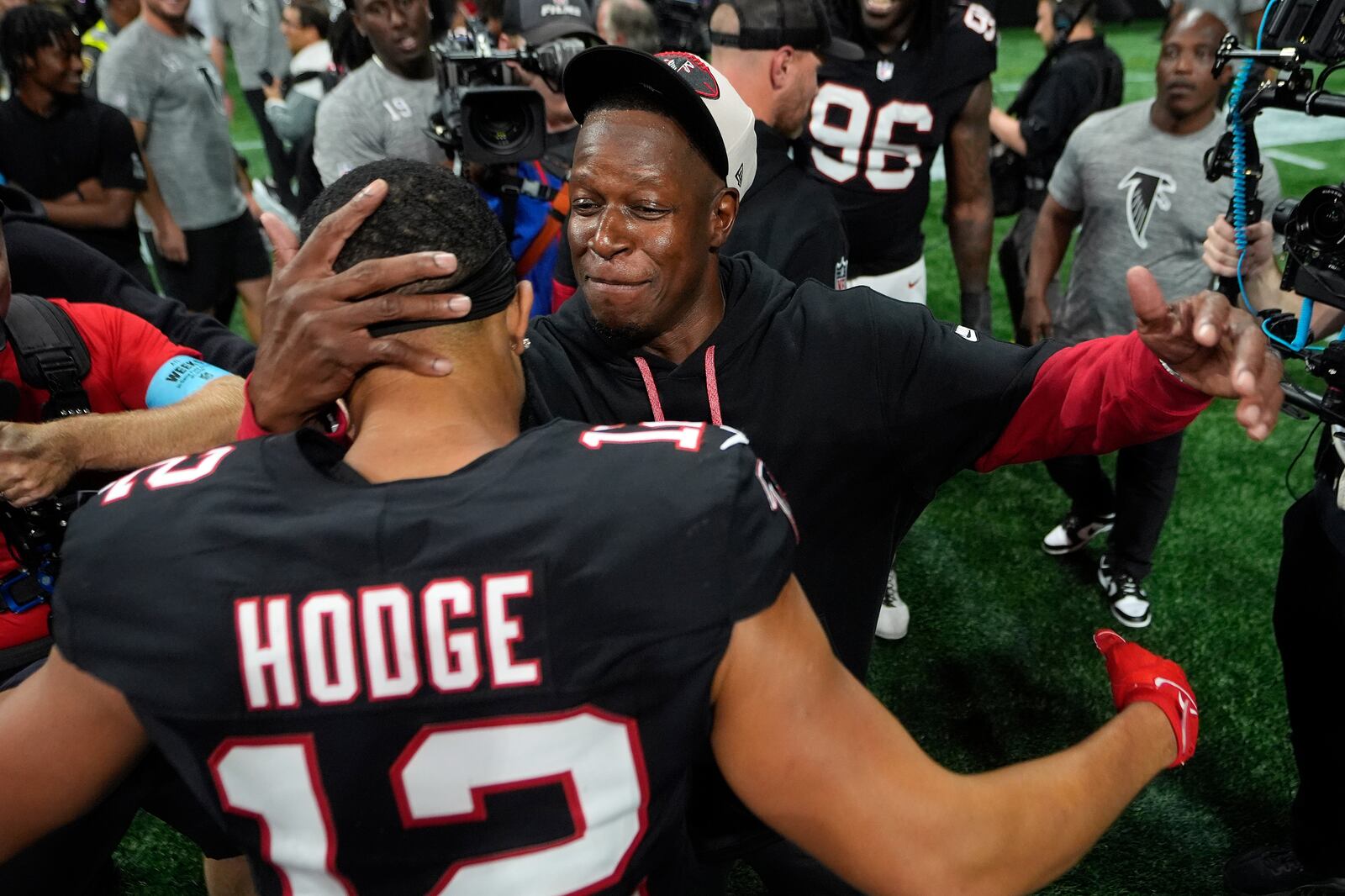 Atlanta Falcons head coach Raheem Morris celebrates with wide receiver KhaDarel Hodge (12) after scoring against the Tampa Bay Buccaneers during overtime in an NFL football game Thursday, Oct. 3, 2024, in Atlanta. (AP Photo/John Bazemore)