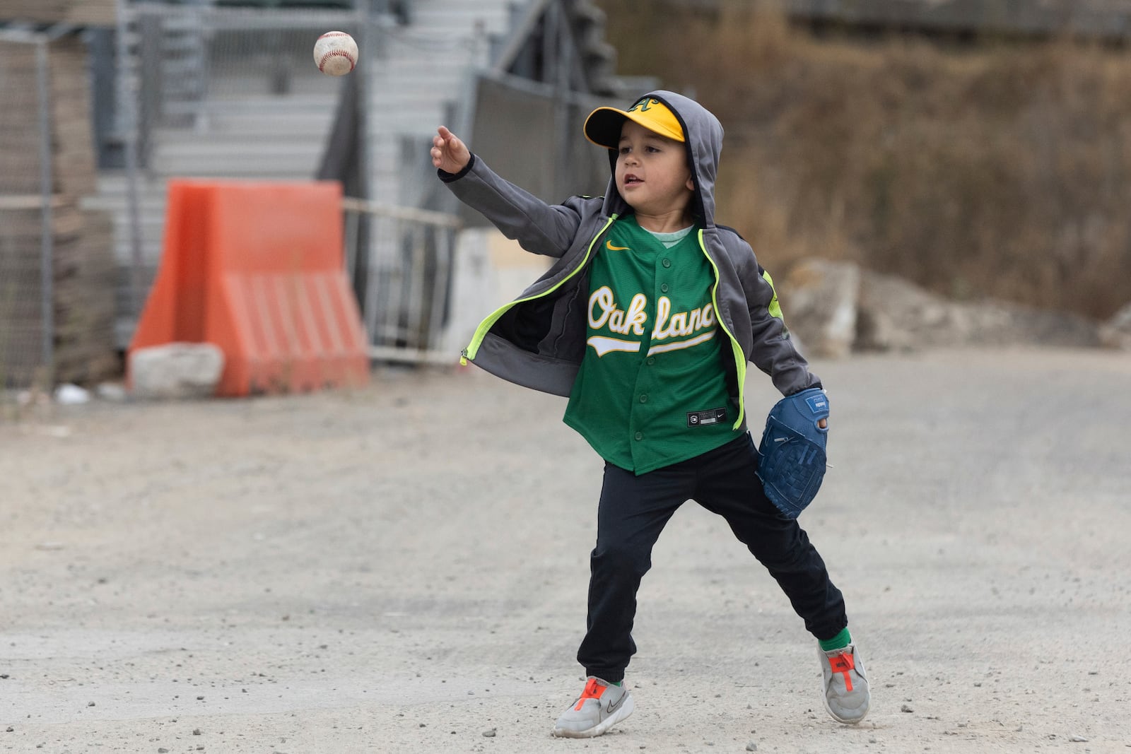 Adam, four-years-old, plays catch outside the Oakland Coliseum before a baseball game between the Oakland Athletics and the Texas Rangers Thursday, Sept. 26, 2024, in Oakland, Calif. (AP Photo/Benjamin Fanjoy)