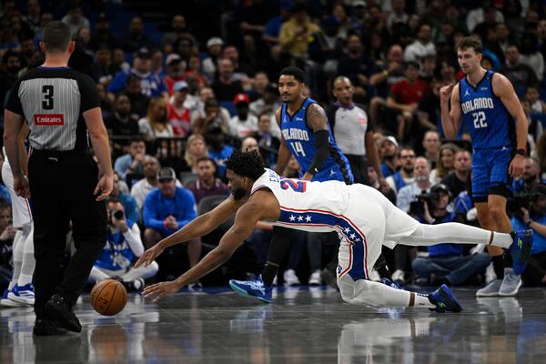 Philadelphia 76ers center Joel Embiid (21) dives after a loose ball against the Orlando Magic during the first half of an Emirates NBA Cup basketball game, Friday, Nov. 15, 2024, in Orlando, Fla. (AP Photo/Phelan M. Ebenhack)