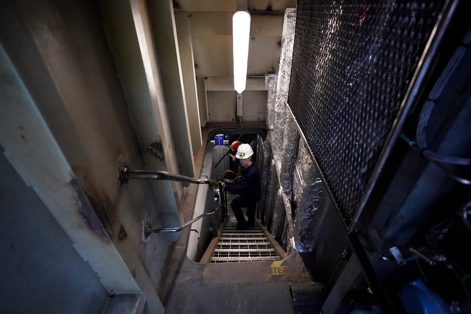 Abigail Jablansky, head of project management, walks down the stairs on the NH3 Kraken, a tugboat powered by ammonia, Friday, Sept. 13, 2024, in Kingston, N.Y. (AP Photo/Alyssa Goodman)