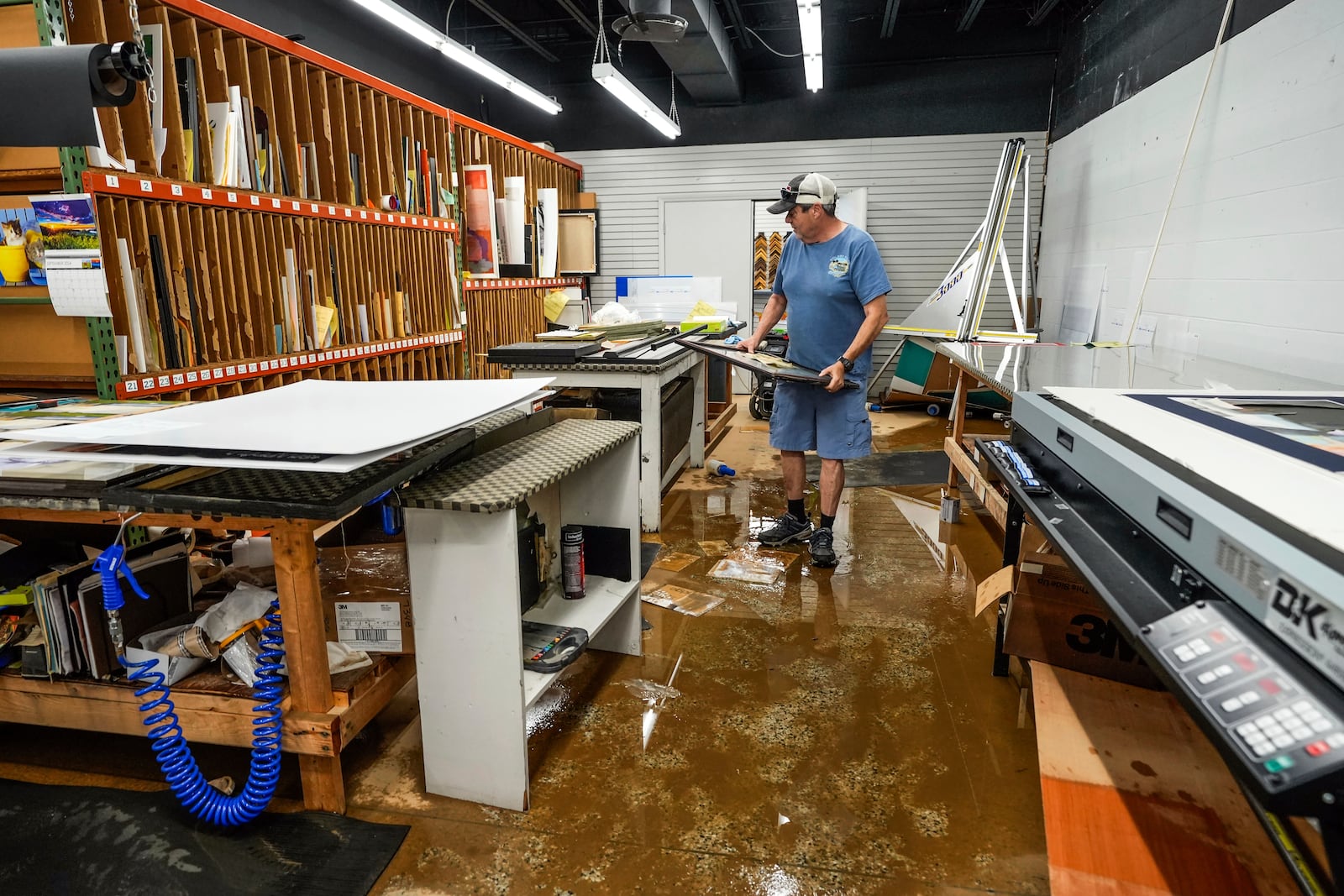 Jason Whisnant, General Manager at International Moulding checks frames for damage from flooding due to Hurricane Helene in the production room of his store, a frame shop on North Green Street, Monday, Sept. 30, 2024, in Morganton, N.C. (AP Photo/Kathy Kmonicek)