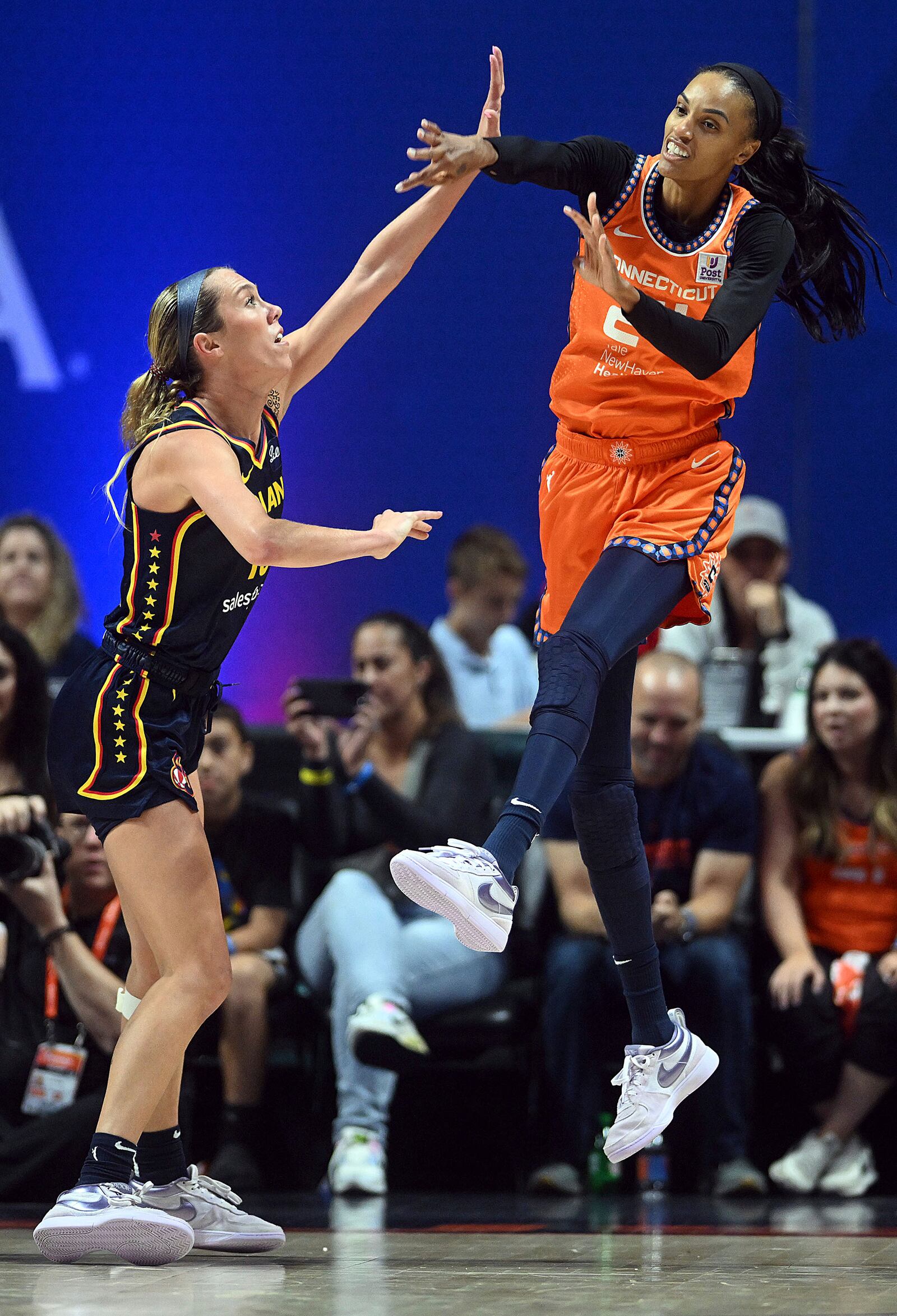 Connecticut Sun's DeWanna Bonner, right, throws a pass past Indiana Fever's Lexie Hull, left, during a first-round WNBA basketball playoff game at Mohegan Sun Arena, Sunday, Sept. 22, 2024. (Sarah Gordon/The Day via AP)