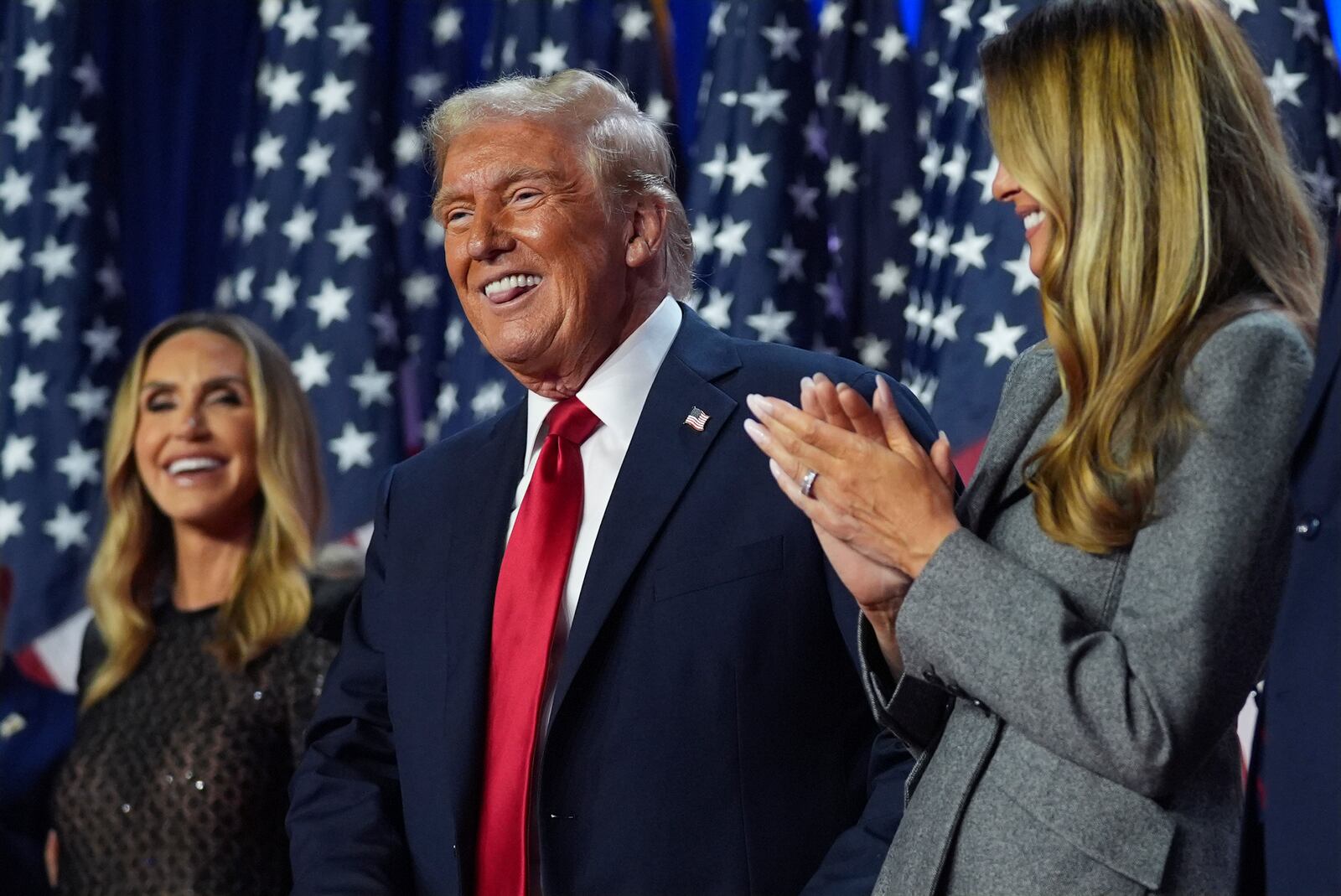 Republican presidential nominee former President Donald Trump stands on stage with former first lady Melania Trump, as Lara Trump watches, at an election night watch party at the Palm Beach Convention Center, Wednesday, Nov. 6, 2024, in West Palm Beach, Fla. (AP Photo/Evan Vucci)