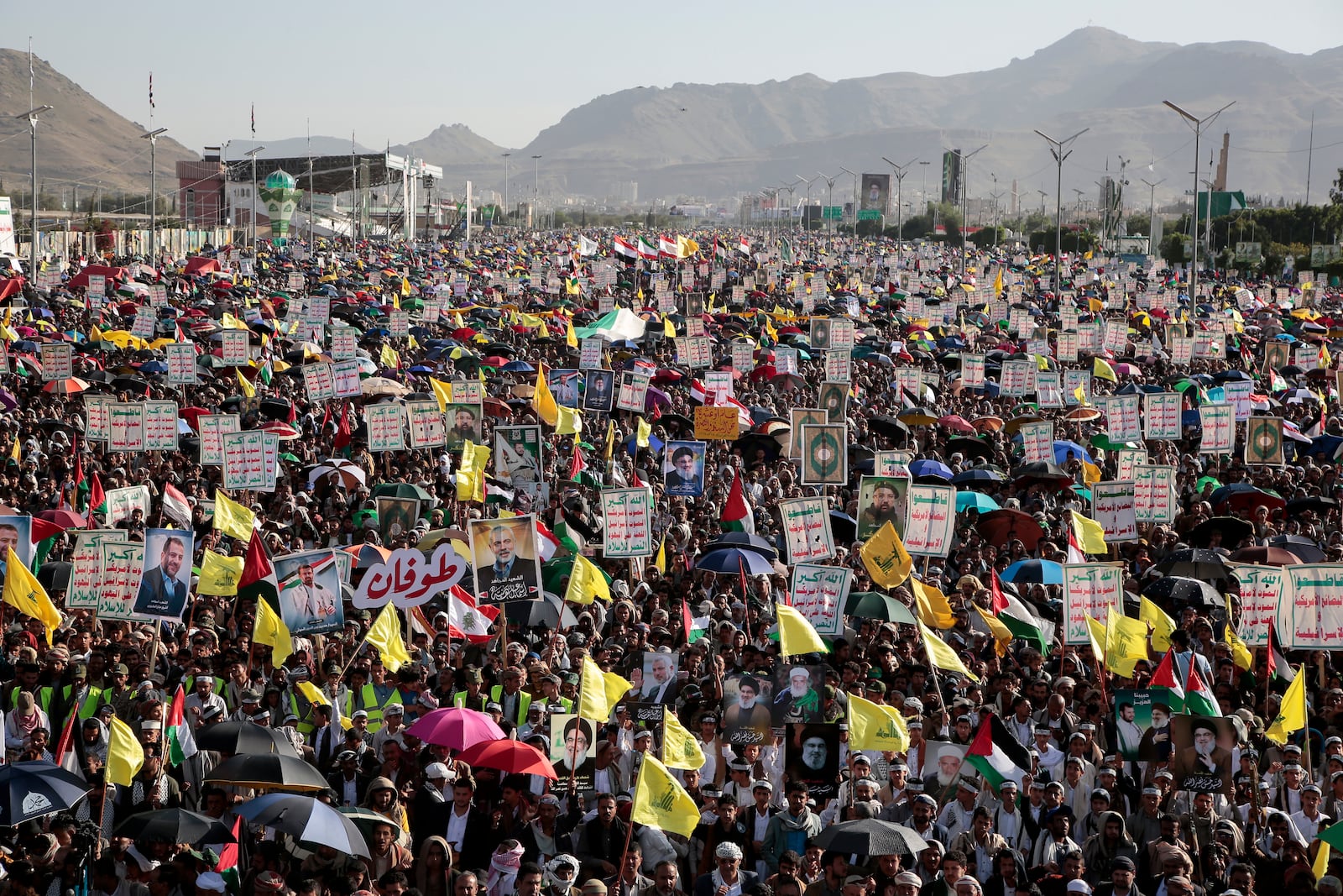 Thousands of Houthi supporters raise Hezbollah flags and posters of late leader Hassan Nasrallah during a rally to commemorate the one-year anniversary of the war in the Gaza Strip, in Sanaa, Yemen, Monday, Oct. 7, 2024. (AP Photo/Osamah Abdulrahman)