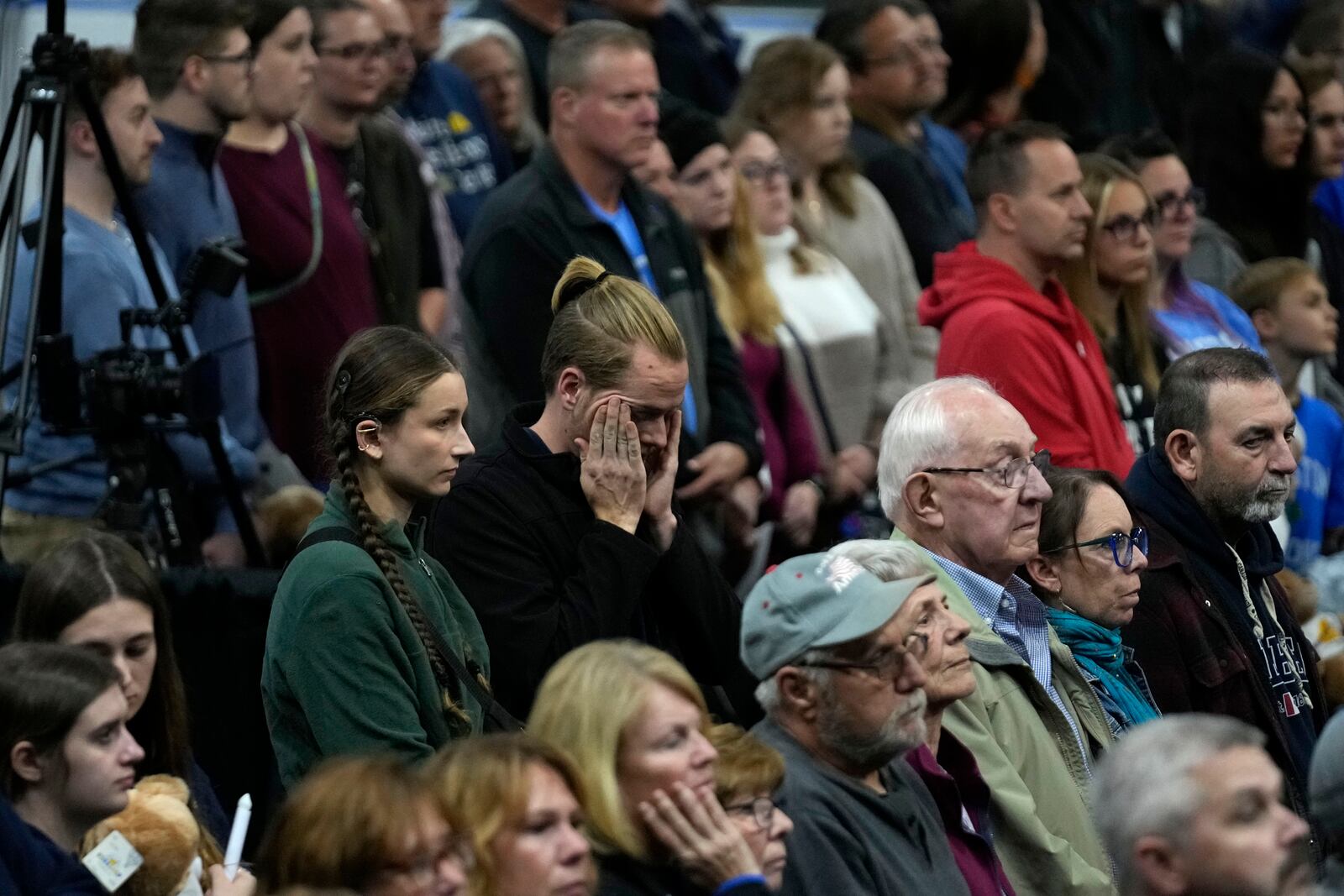 Attendees stand during the playing of Amazing Grace at a commemoration event to mark the one year anniversary of the mass shooting in Lewiston, Maine, Friday, Oct. 25, 2024. (AP Photo/Robert F. Bukaty)