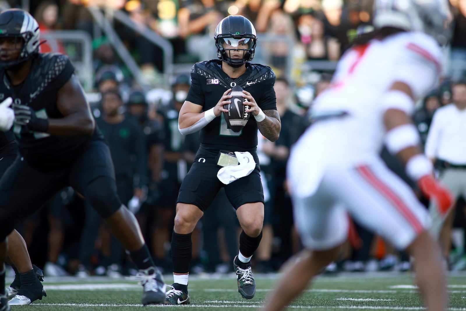 Oregon quarterback Dillon Gabriel, center, looks to pass the ball during an NCAA college football game against Ohio State, Saturday, Oct. 12, 2024, in Eugene, Ore. (AP Photo/Lydia Ely)