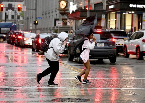 Pedestrians rush across Smithfield St. in the rain in Downtown Pittsburgh on Tuesday, April 29, 2025. (Sebastian Foltz/Pittsburgh Post-Gazette via AP)