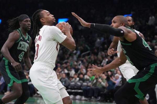 Cleveland Cavaliers guard Darius Garland (10) drives to the basket against Boston Celtics center Al Horford, right, during the first half of an Emirates NBA Cup basketball game, Tuesday, Nov. 19, 2024, in Boston. (AP Photo/Charles Krupa)