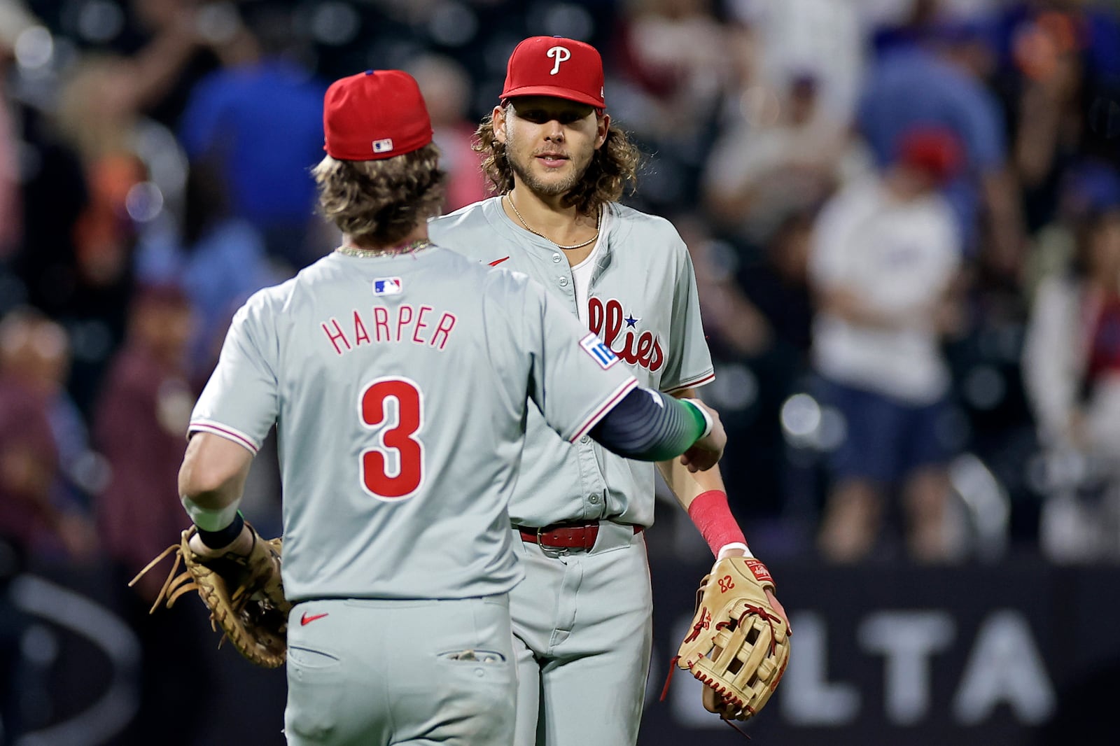 Philadelphia Phillies third baseman Alec Bohm, right, and Bryce Harper (3) celebrate after defeating the New York Mets in a baseball game Friday, Sept. 20, 2024, in New York. (AP Photo/Adam Hunger)