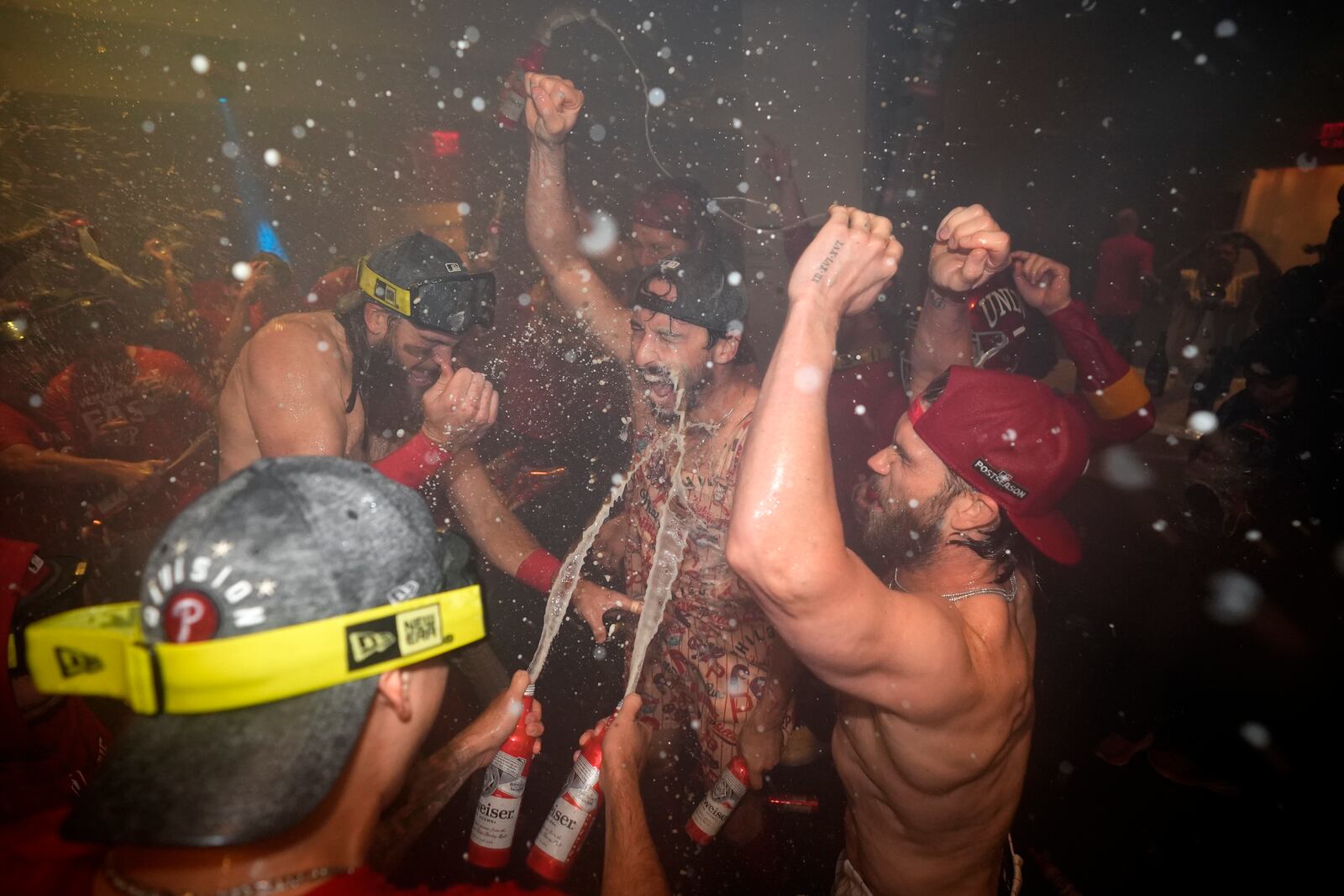 Philadelphia Phillies' Brandon Marsh, from left, Garrett Stubbs and Bryce Harper celebrate after the Phillies won a baseball game against the Chicago Cubs to clinch the NL East title, Monday, Sept. 23, 2024, in Philadelphia. (AP Photo/Matt Slocum)