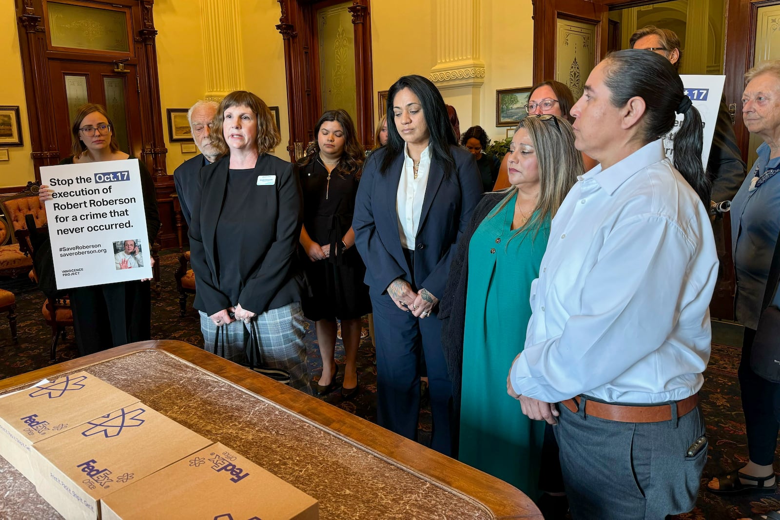 Elizabeth Ramirez, center, Casandra Rivera, center right, and Anna Vasquez, second from right, of the "San Antonio 4" group, deliver boxes with petitions in the Texas State capitol for Texas Gov. Greg Abbott seeking the pardoning of Robert Roberson's execution, Wednesday, Oct. 16, 2024, in Austin, Texas. Roberson, 57, is scheduled to receive a lethal injection on Oct. 17, for the 2002 killing of his 2-year-old daughter, Nikki Curtis, in the East Texas city of Palestine. Roberson has long proclaimed his innocence. (AP Photo/Nadia Lathan)