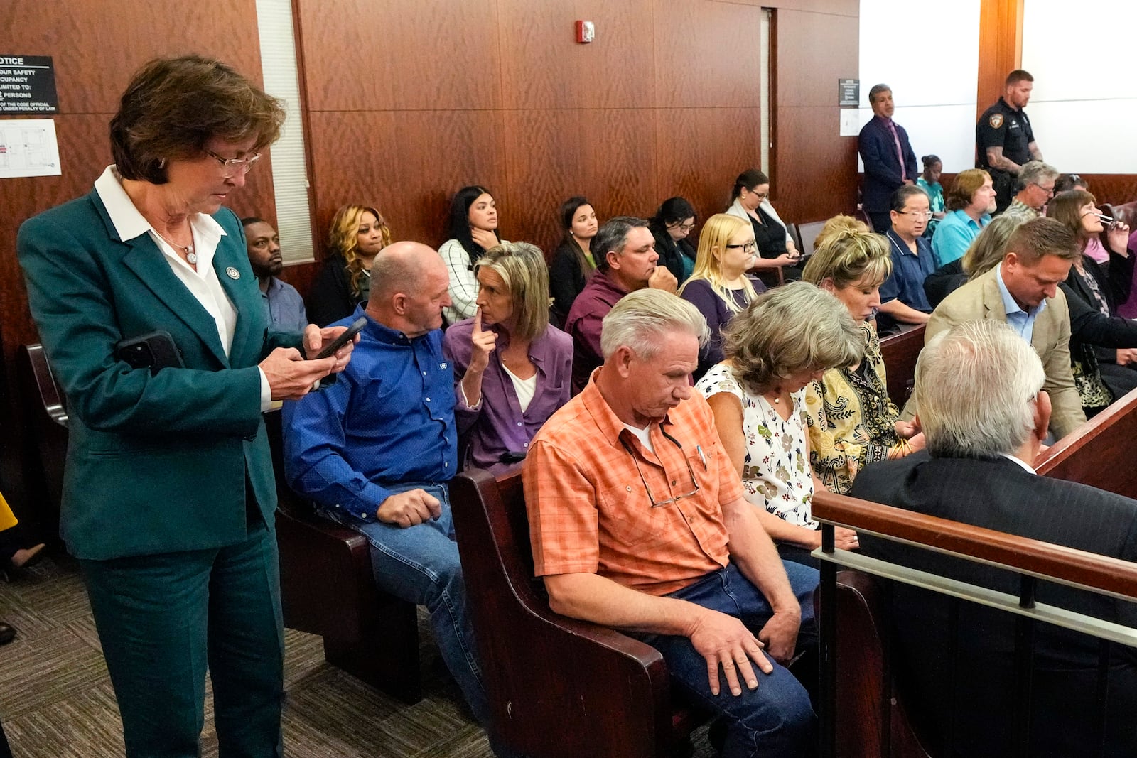 Harris County District Attorney Kim Ogg, left, stand with the families Dennis Tuttle and Rhogena Nicholas after former Houston police officer Gerald Goines was sentenced to 60 years behind bars on a pair of felony murder convictions on Tuesday, Oct. 8, 2024, in Houston. Goines was found guilty of felony murder in the 2019 deaths of Tuttle and Nicholas. (Brett Coomer/Houston Chronicle via AP)