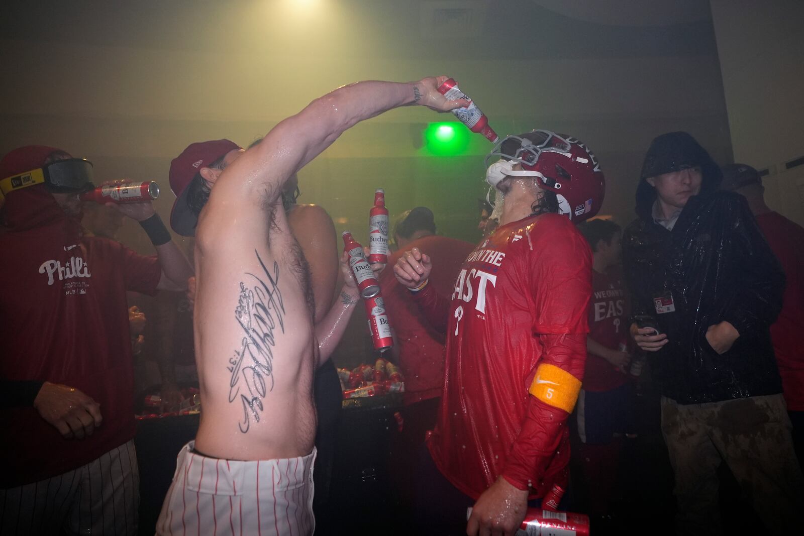 Philadelphia Phillies' Bryson Stott, right, and Bryce Harper celebrate after the Phillies won a baseball game against the Chicago Cubs to clinch the NL East title, Monday, Sept. 23, 2024, in Philadelphia. (AP Photo/Matt Slocum)