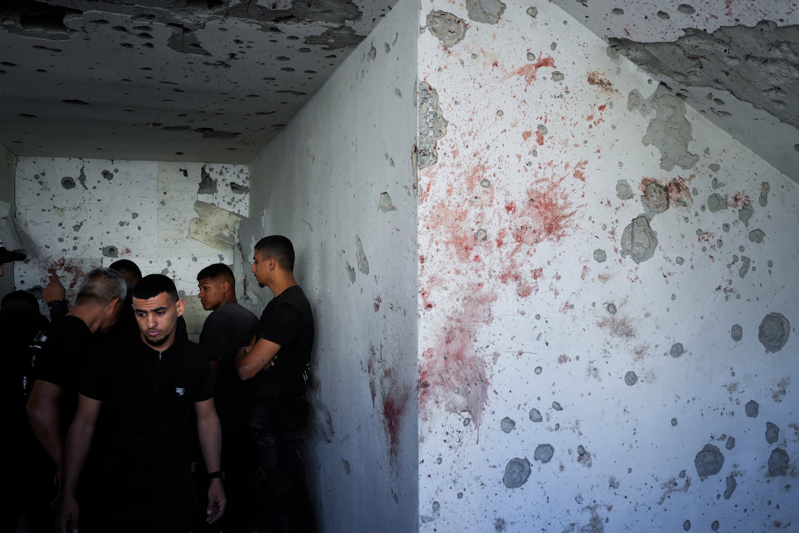 Neighbors examine the damaged house where one person was killed after a projectile launched from Lebanon slammed into Maalot-Tarshiha, northern Israel, Tuesday, Oct. 29, 2024. (AP Photo/Ohad Zwigenberg)