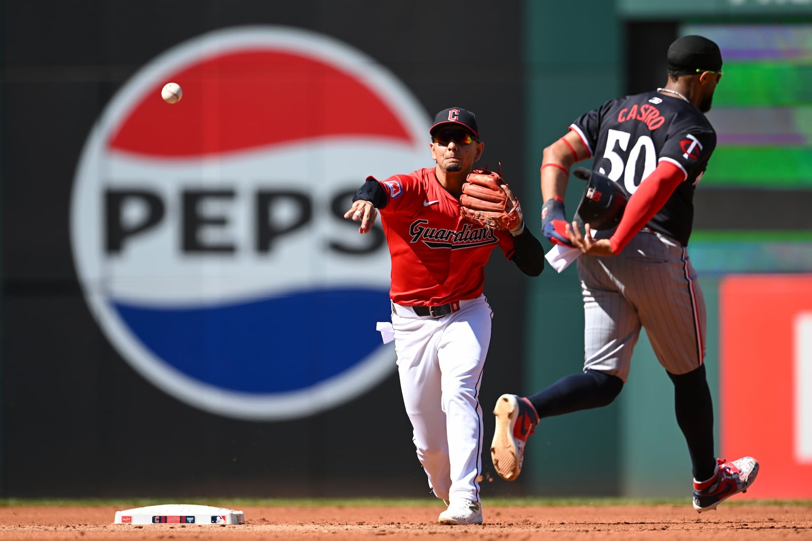 Cleveland Guardians' Andrés Giménez, left, throws out Minnesota Twins' Manuel Margot at first base after forcing out Willi Castro (50) at second base to complete a double play during the third inning of a baseball game, Thursday, Sept. 19, 2024, in Cleveland. (AP Photo/Nick Cammett)