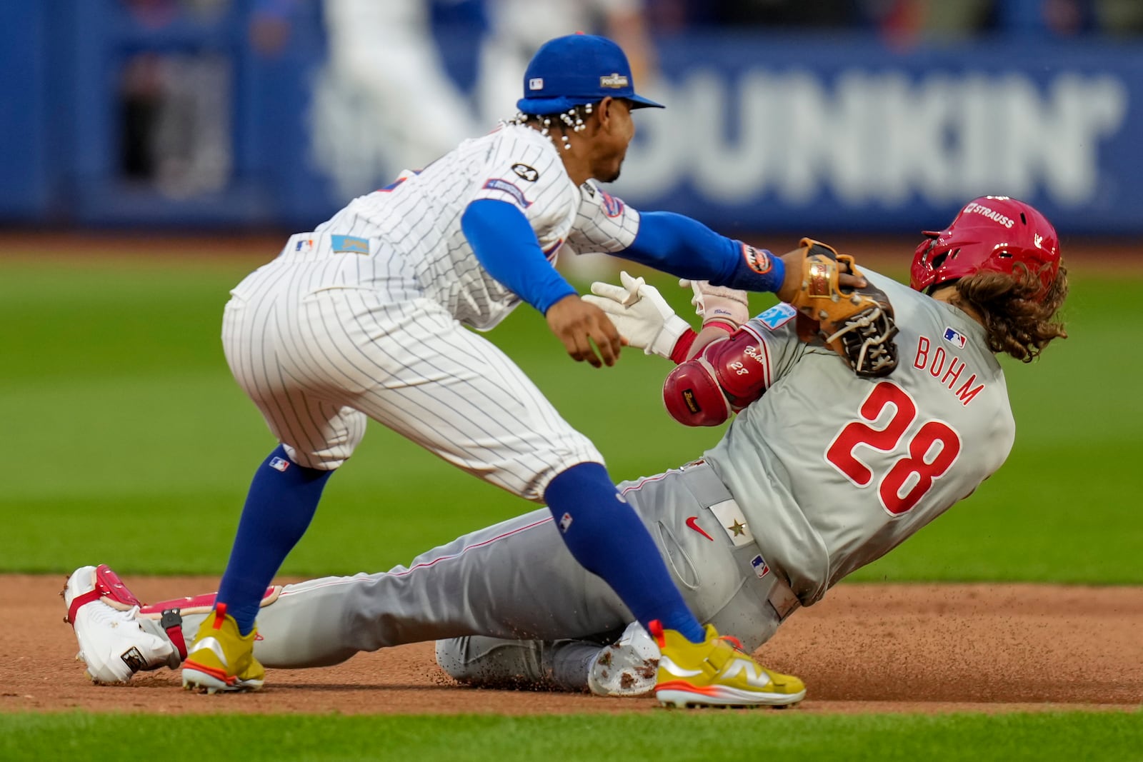 New York Mets shortstop Francisco Lindor (12) tags out Philadelphia Phillies' Alec Bohm (28) as Bohm attempts to stretch a base hit into a double during the fourth inning of Game 3 of the National League baseball playoff series, Tuesday, Oct. 8, 2024, in New York. (AP Photo/Seth Wenig)