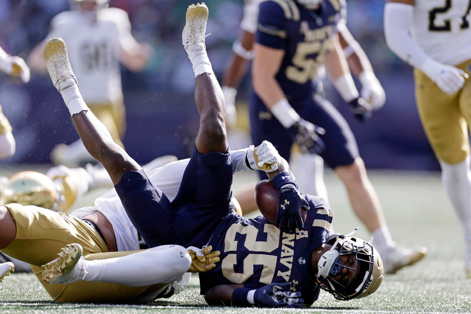 Navy running back Isaiah Bryant (25) is tackled by Notre Dame defensive lineman Loghan Thomas during the first half of an NCAA college football game Saturday, Oct. 26, 2024, in East Rutherford, N.J. (AP Photo/Adam Hunger)