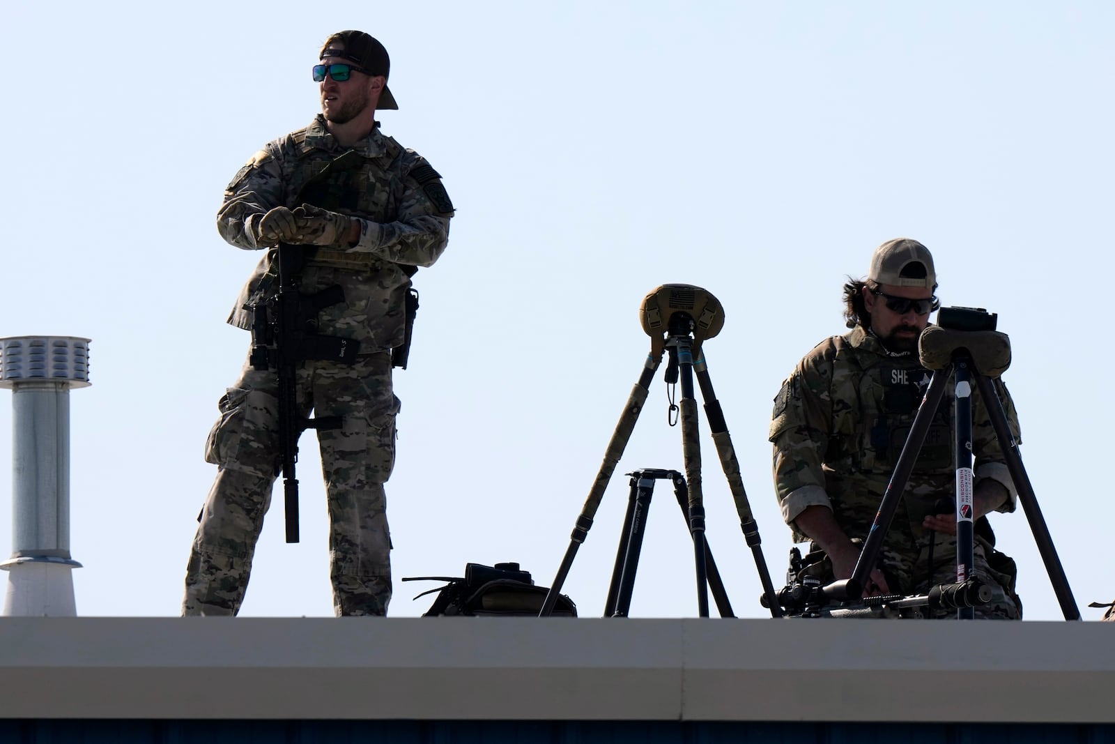 Law enforcement snipers look out from a roof before Republican presidential nominee former President Donald Trump arrives to speak at a campaign rally at Dodge County Airport, Sunday, Oct. 6, 2024, in Juneau, Wis. (AP Photo/Julia Demaree Nikhinson)