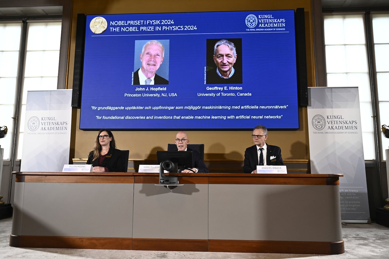 John Hopfield and Geoffrey Hinton, seen in picture, are awarded this year's Nobel Prize in Physics, which is announced at a press conference by Hans Ellergren, center, permanent secretary at the Swedish Academy of Sciences in Stockholm, Sweden Tuesday Oct. 8, 2024. (Christine Olsson/TT News Agency via AP)