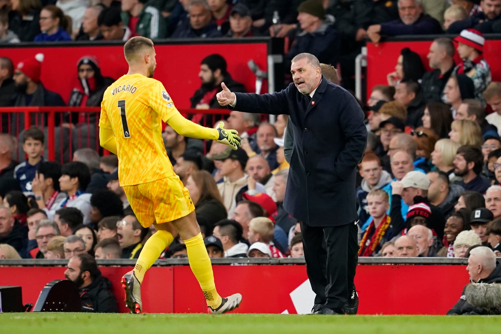 Tottenham's head coach Ange Postecoglou, right, talks to Tottenham's goalkeeper Guglielmo Vicario during the English Premier League soccer match between Manchester United and Tottenham Hotspur at Old Trafford stadium in Manchester, England, Sunday, Sept. 29, 2024. (AP Photo/Dave Thompson)