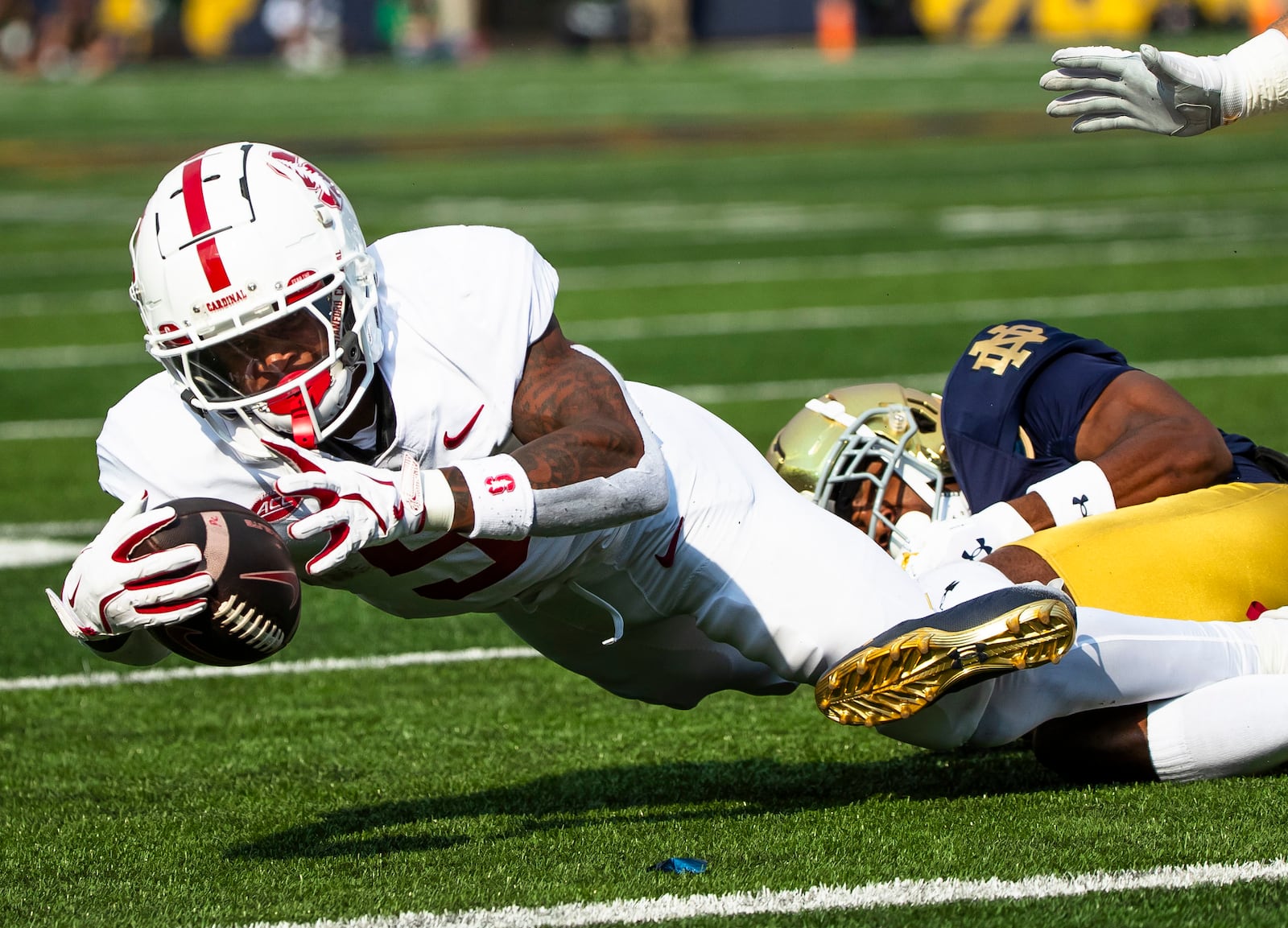 Stanford running back Chris Davis Jr., left, reaches for extra yards as Notre Dame defensive back Benjamin Morrison, right, tackles him during an NCAA college football game Saturday, Oct. 12, 2024, in South Bend, Ind. (AP Photo/Michael Caterina)