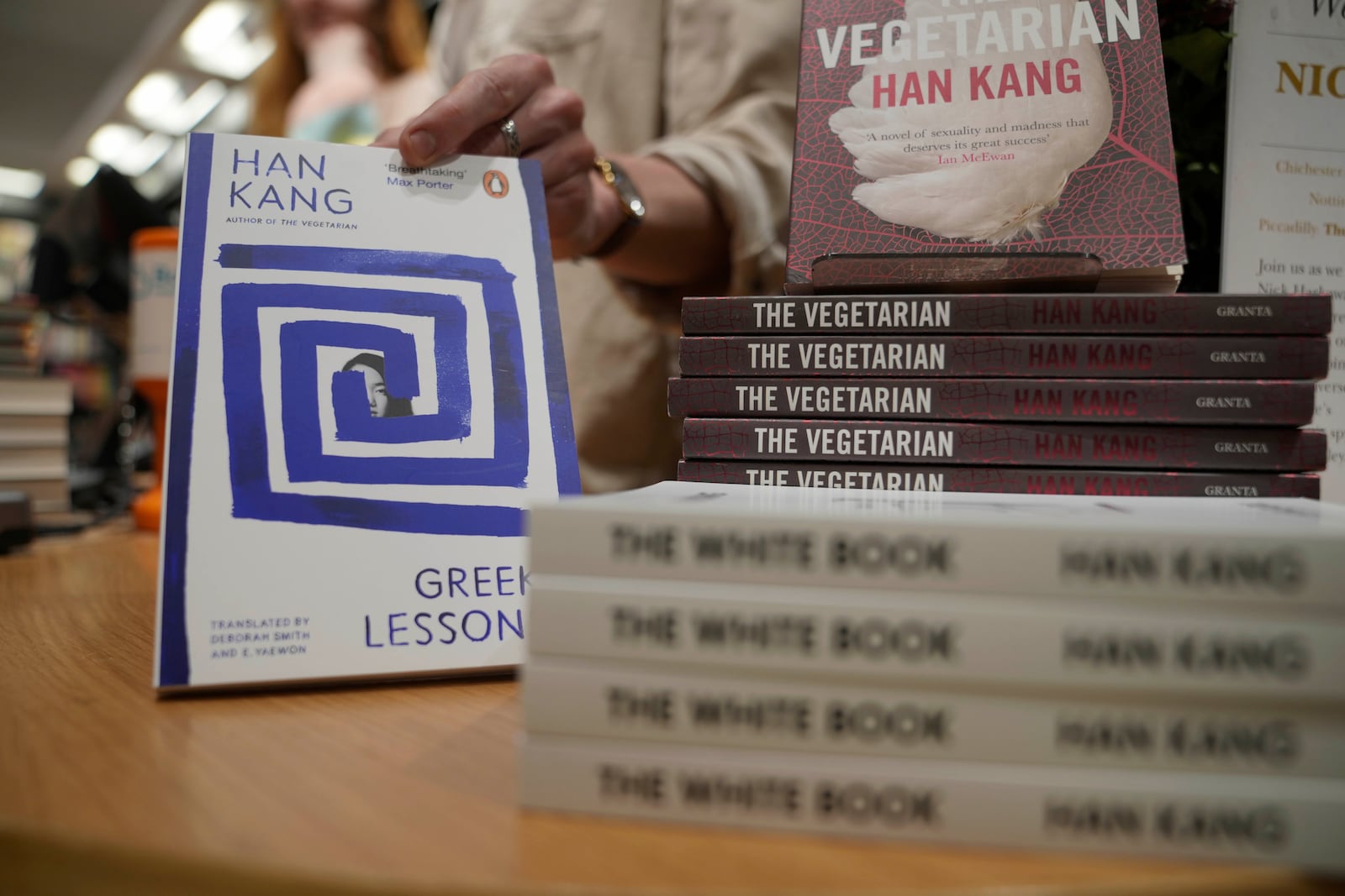 A book store employee handles books by the South Korean writer Han Kang in London, Thursday, Oct. 10, 2024. Kang has been awarded the Nobel Prize for Literature. (AP Photo/Kin Cheung)