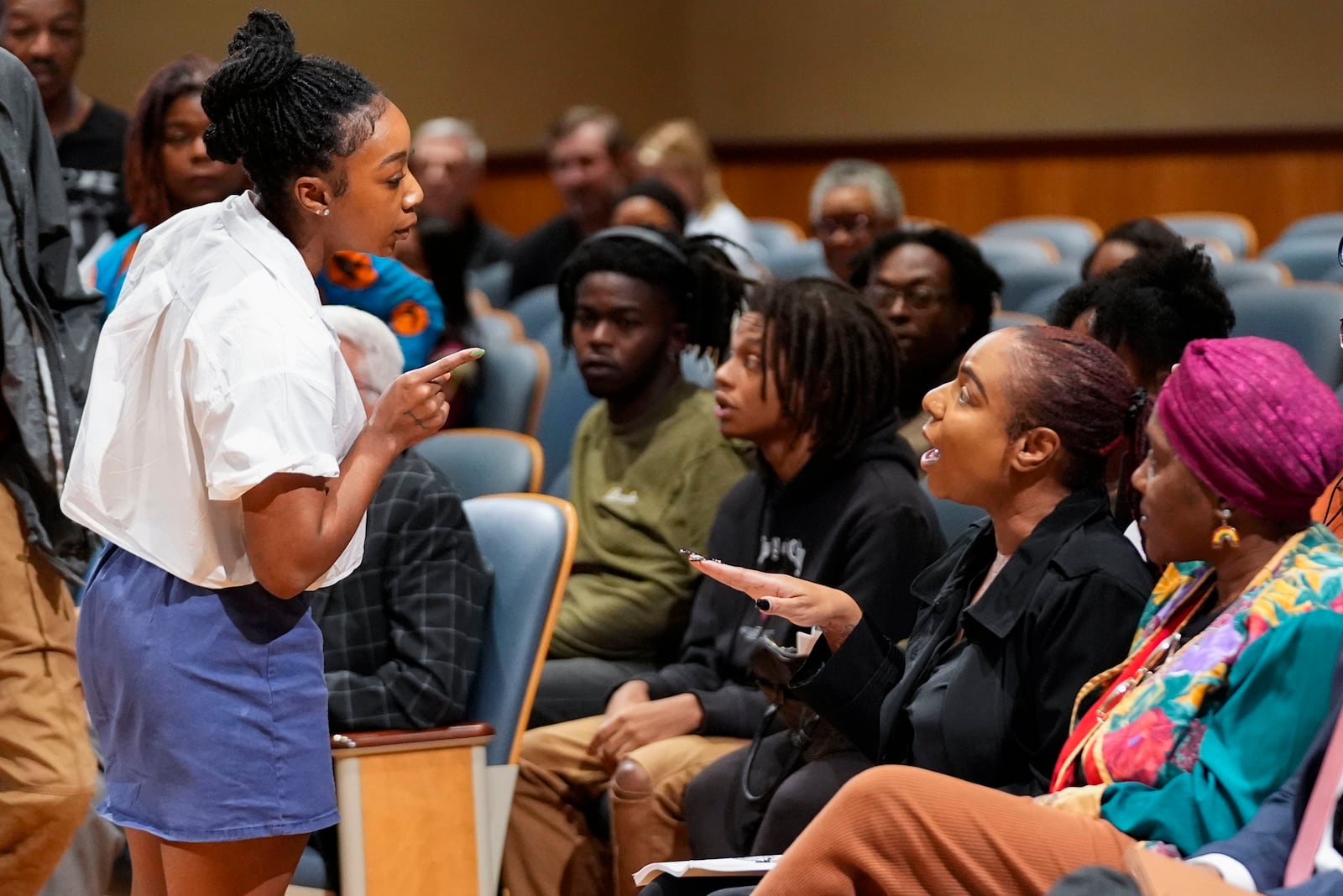 Simone Haley, granddaughter of Oretha Castle Haley, challenges Lakita Smith, seated with Candice Henderson-Chandler, after speaking during a city council hearing regarding the dispute over her grandmother's former home and plans by the property owner, Henderson-Chandler, to create a museum, in New Orleans, Thursday, Oct. 24, 2024. (AP Photo/Gerald Herbert)