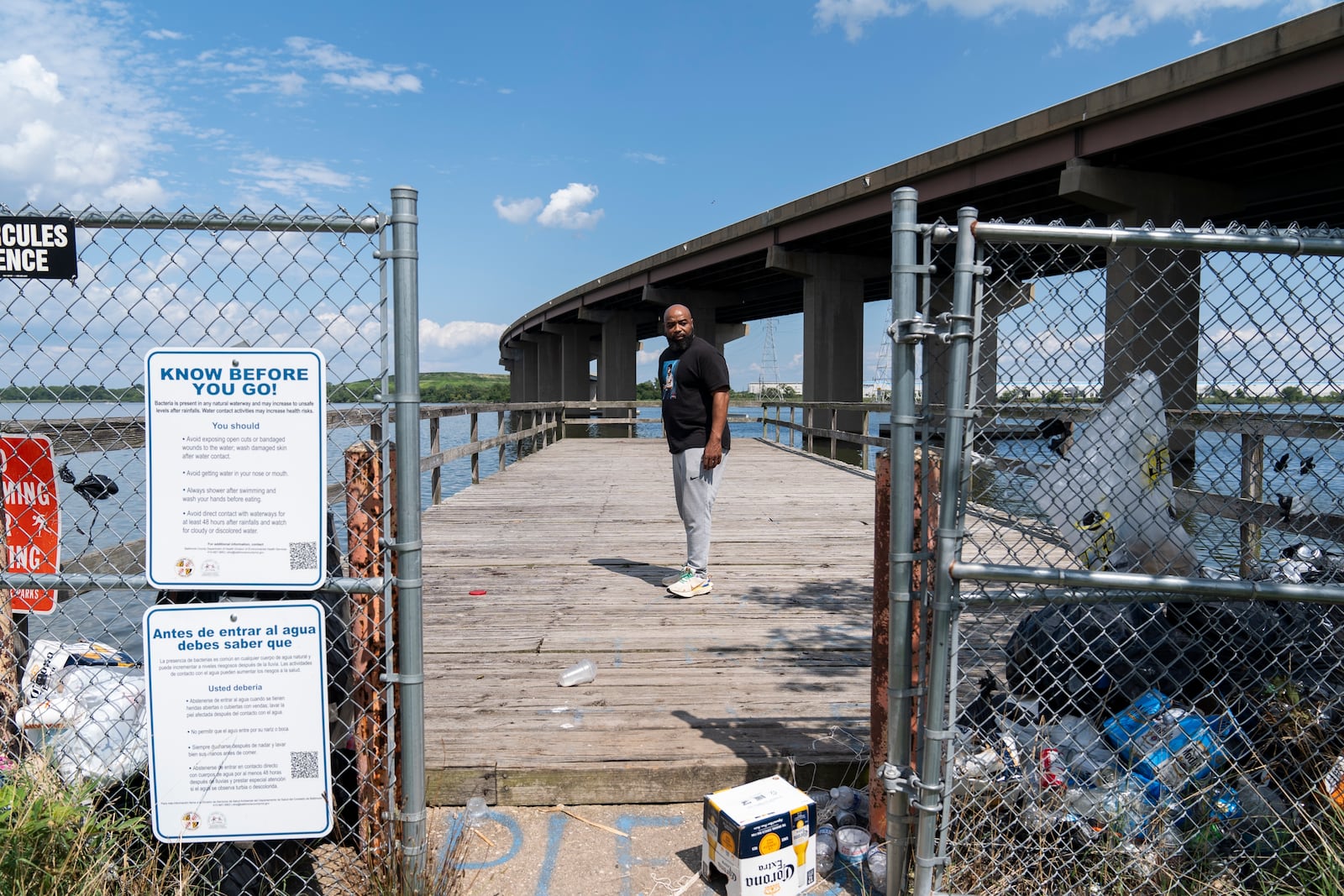 Turner Station resident Marquis Neal looks toward garbage that has piled up on a pier at Fleming Park in Turner Station, Md., Tuesday, Aug. 13, 2024. (AP Photo/Stephanie Scarbrough)