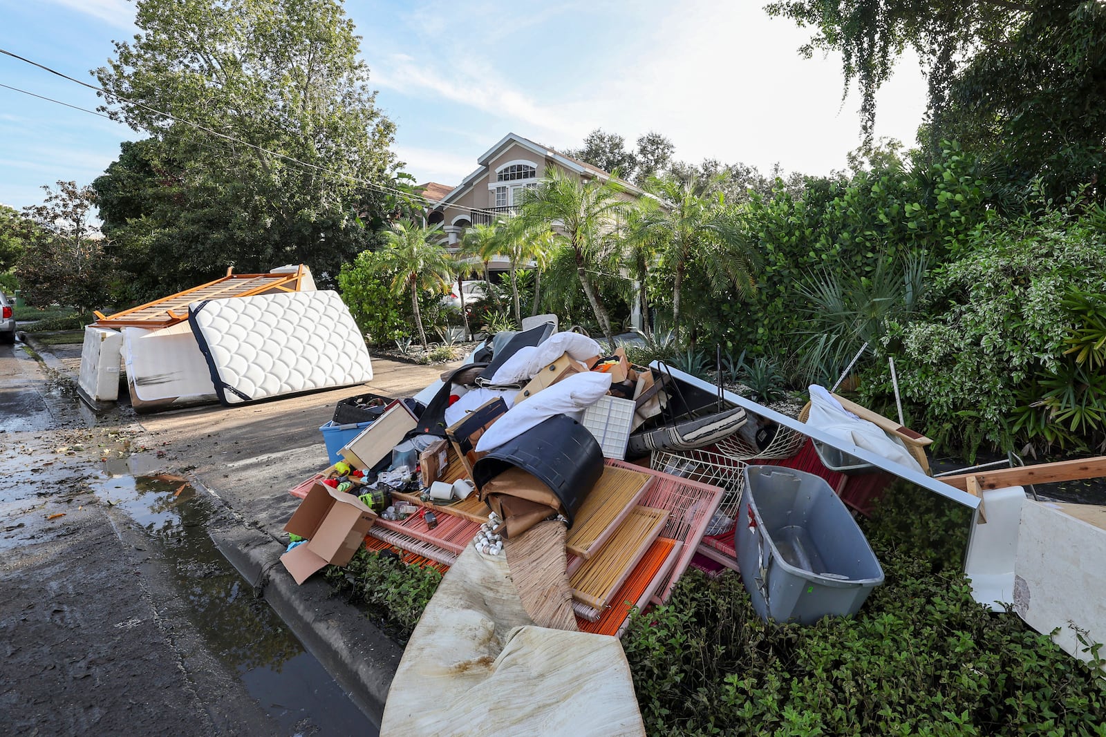 Residents continue to clean our from flooding caused by Hurricane Helene in the Davis Island community on Saturday, Sept. 28, 2024, in Tampa, Fla. (AP Photo/Mike Carlson)