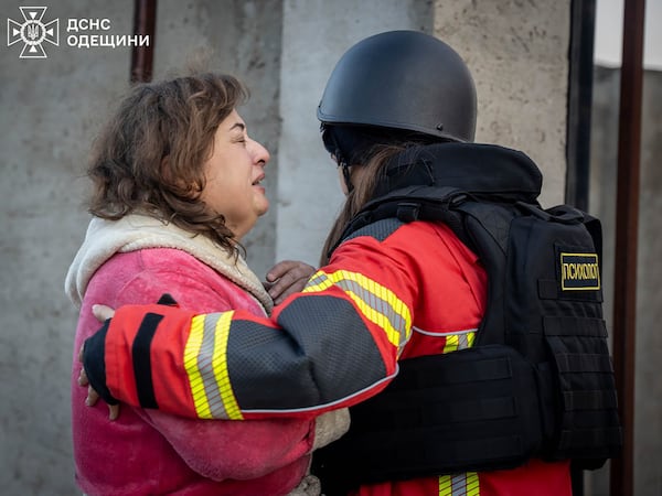 In this photo provided by the Ukrainian Emergency Service, a psychologist calms down a woman who lost her home in Russian missile attack in Odesa region, Ukraine, Sunday, Nov. 17, 2024. (Ukrainian Emergency Service via AP)