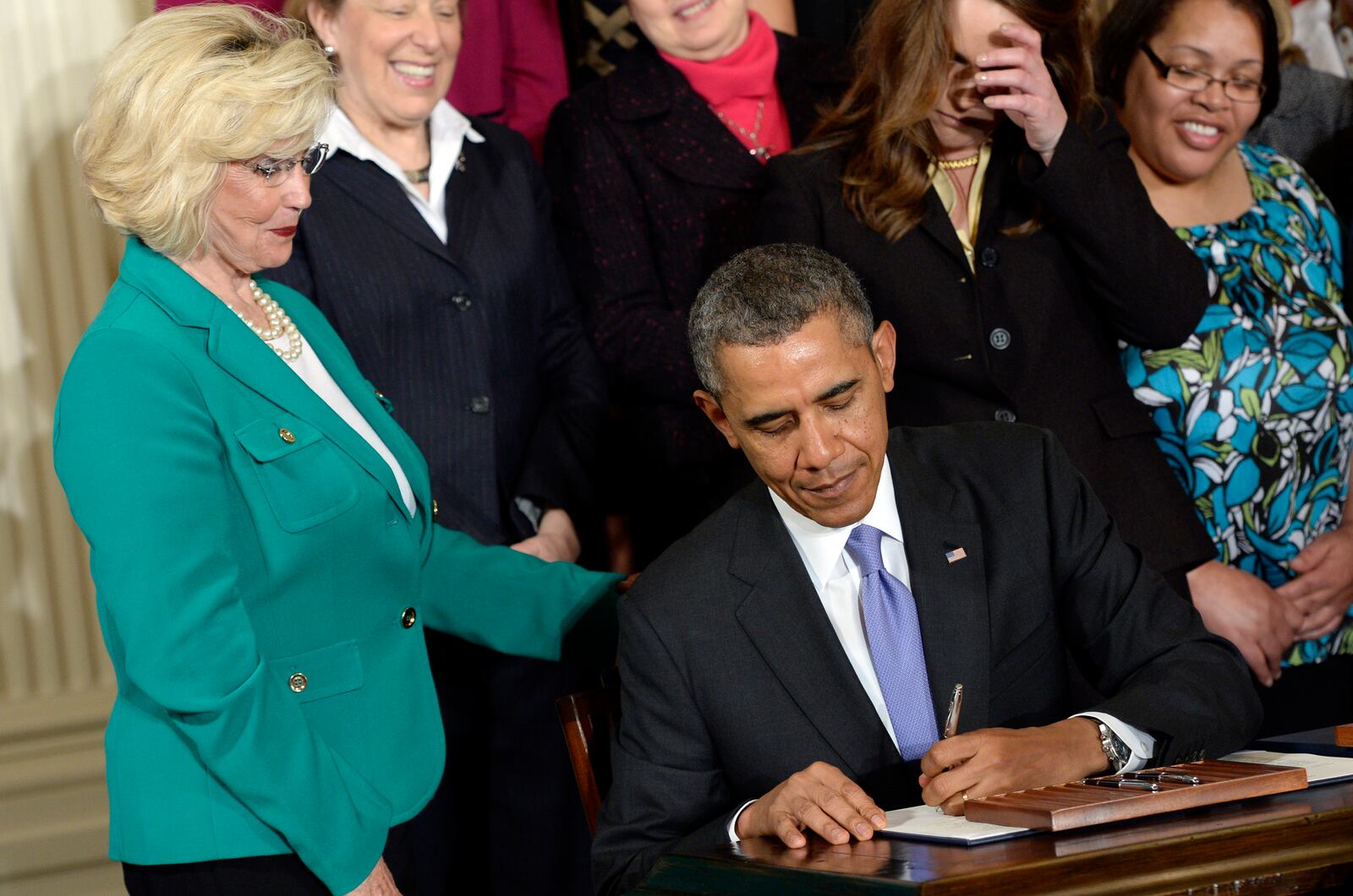 FILE - Lilly Ledbetter watches as President Barack Obama signs executive actions, with pending Senate legislation, aimed at closing a compensation gender gap that favors men, at the White House in Washington, April 8, 2014, during an event marking Equal Pay Day. (AP Photo/Susan Walsh, File)