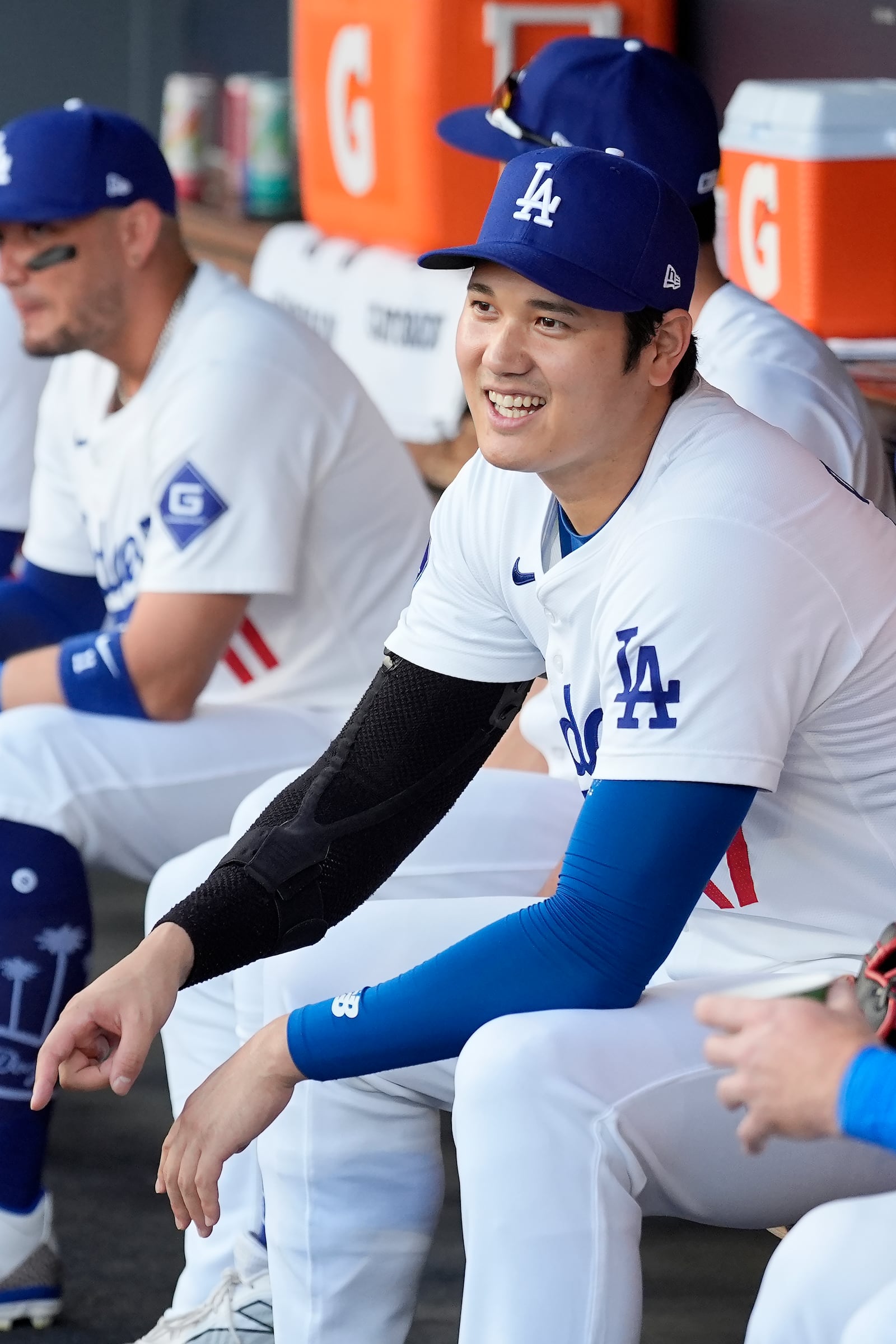 Los Angeles Dodgers' Shohei Ohtani, right, waits for the start of Game 1 of baseball's NL Division Series against the San Diego Padres, Saturday, Oct. 5, 2024, in Los Angeles. (AP Photo/Ashley Landis)