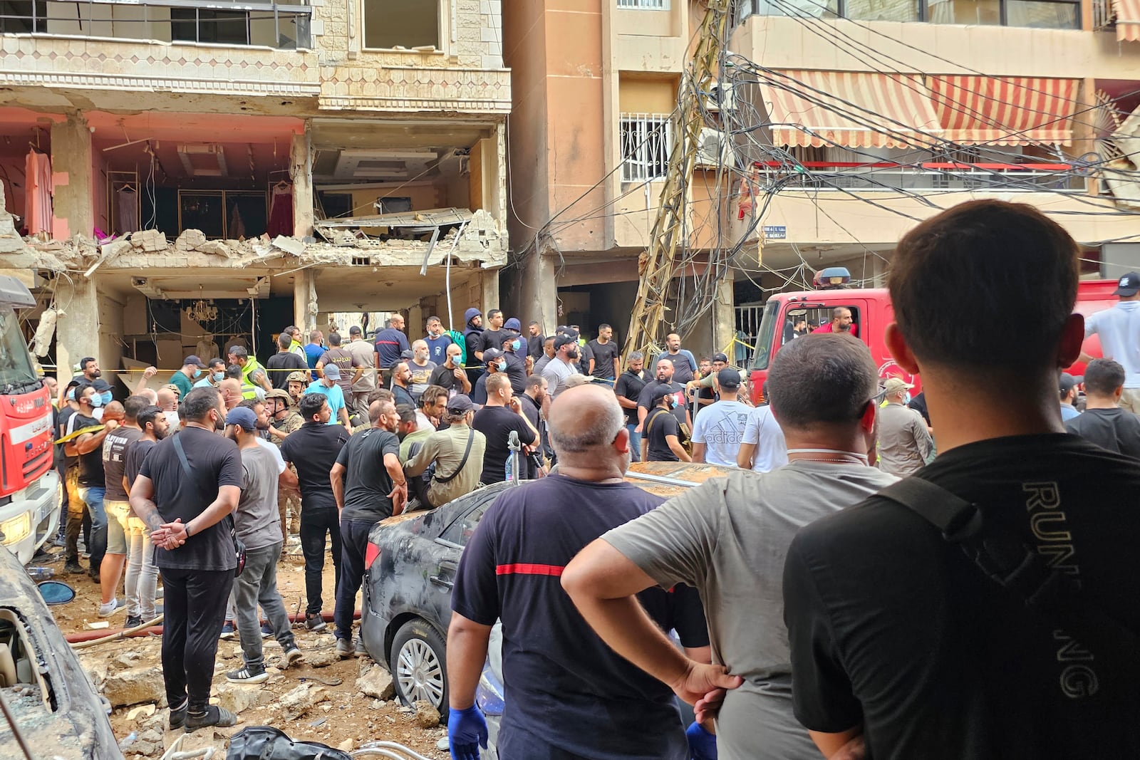 Residents look on as rescuers arrive at the scene of an Israeli missile strike in the southern suburbs of Beirut, Friday, Sept. 20, 2024. (AP Photo/Hassan Ammar)