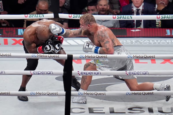 Jake Paul hits Mike Tyson during their heavyweight boxing match, Friday, Nov. 15, 2024, in Arlington, Texas. (AP Photo/Julio Cortez)