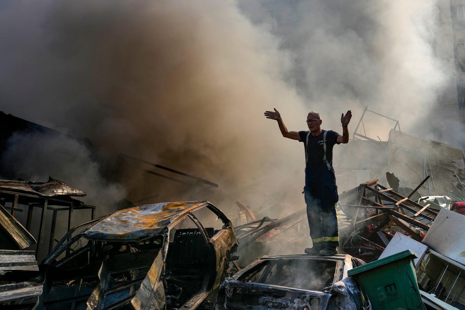 A civil defense worker gestures as smoke rises from the site of an Israeli airstrike in Dahiyeh, Beirut, Lebanon, Friday, Nov. 1, 2024. (AP Photo/Hassan Ammar)