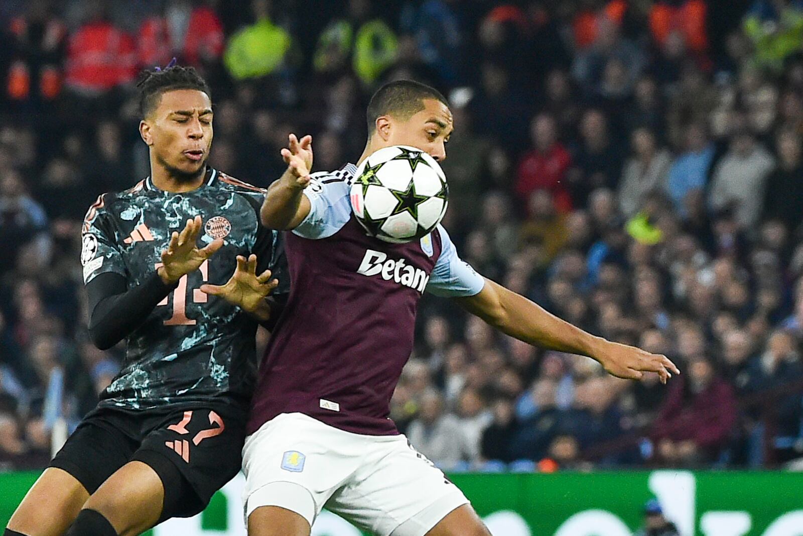 Bayern's Michael Olise, left, duels for the ball with Aston Villa's Youri Tielemans during the Champions League opening phase soccer match between Aston Villa and Bayern Munich, at Villa Park in Birmingham, England, Wednesday, Oct. 2, 2024. (AP Photo/Rui Vieira)