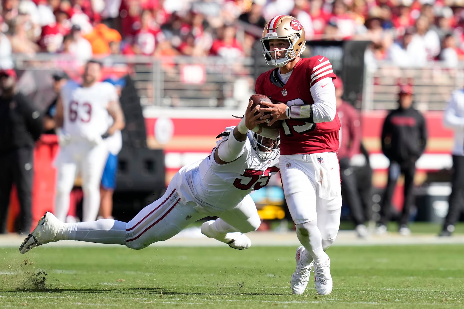 San Francisco 49ers quarterback Brock Purdy, right, scrambles away from Arizona Cardinals defensive tackle Dante Stills during the second half of an NFL football game in Santa Clara, Calif., Sunday, Oct. 6, 2024. (AP Photo/Godofredo A. Vásquez)