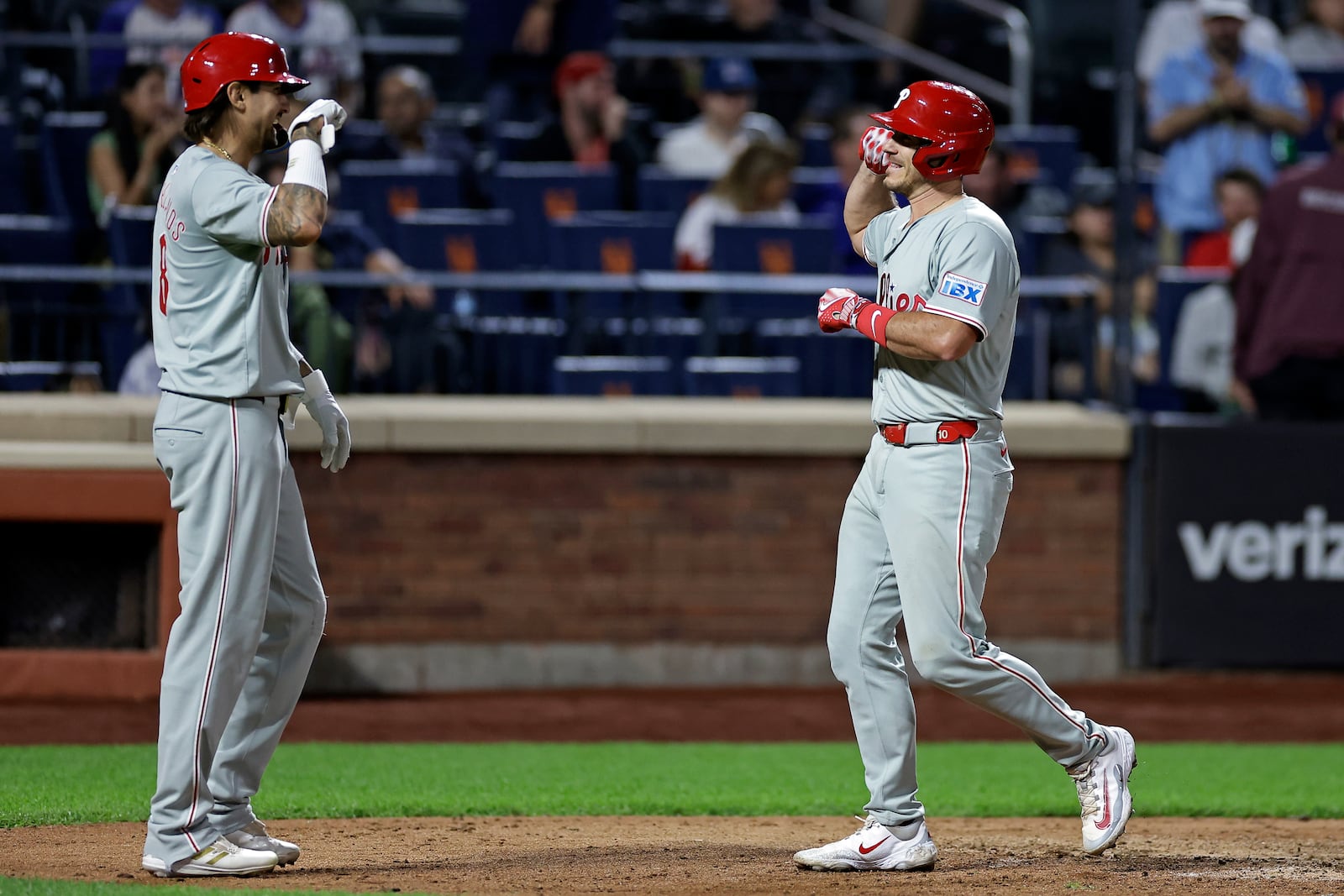 Philadelphia Phillies' J.T. Realmuto, right, is congratulated by Nick Castellanos, left, after hitting a two-run home run during the eighth inning of a baseball game against the New York Mets, Friday, Sept. 20, 2024, in New York. (AP Photo/Adam Hunger)