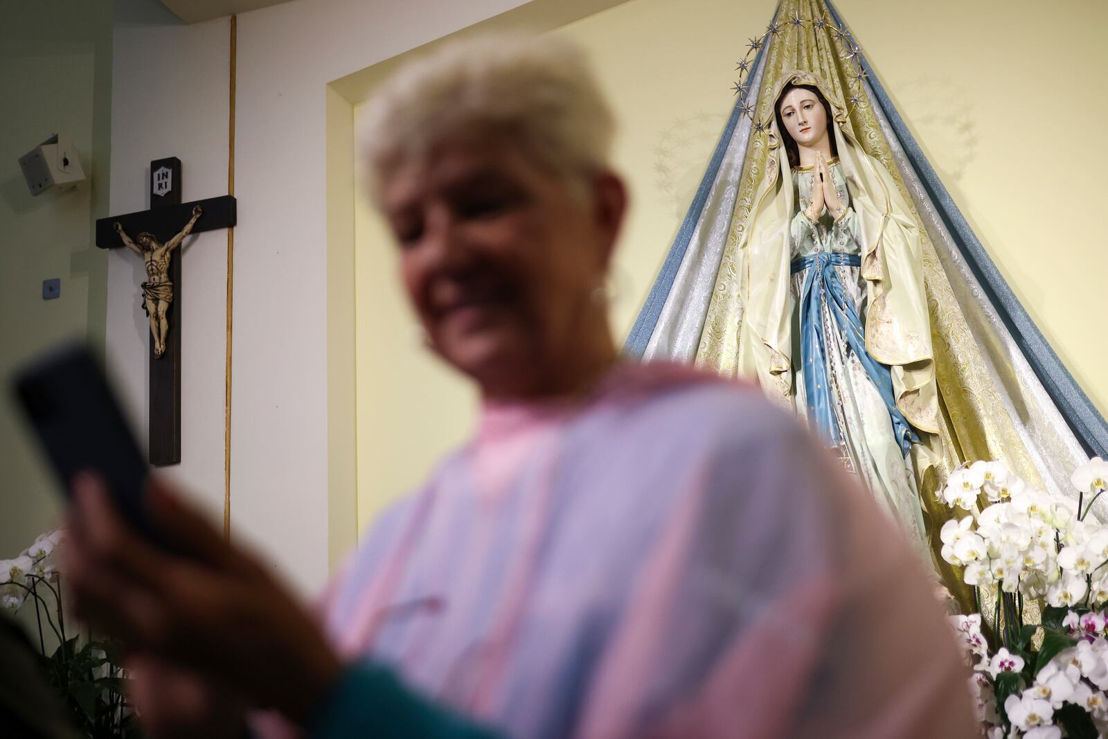 A pilgrim takes a self portrait in front of the statue of the Virgin Mary inside the St. James Church in Medjugorje, Bosnia, Thursday, Sept. 19, 2024. (AP Photo/Armin Durgut)